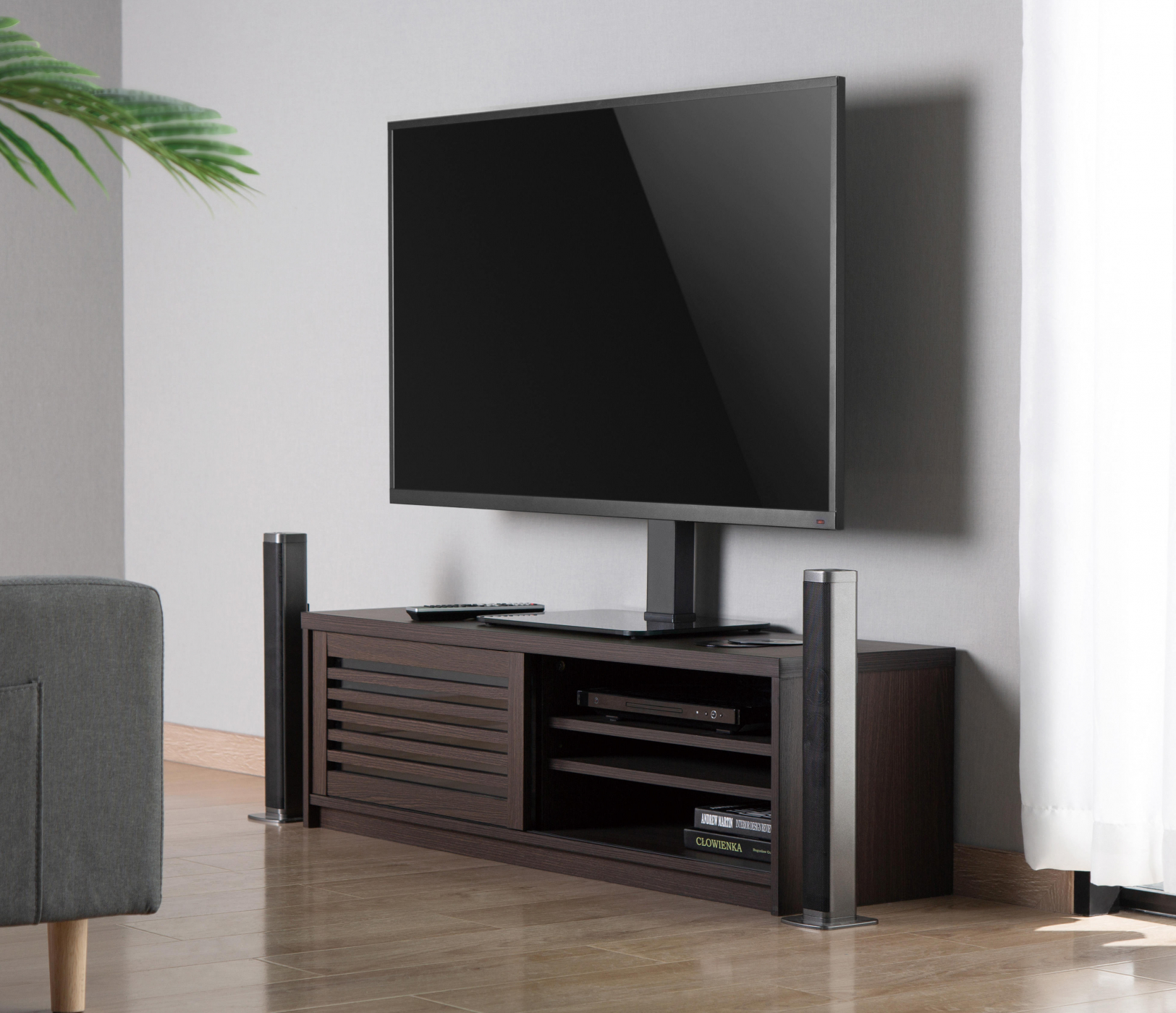 Wohnzimmer mit Fernseher auf einem Ständer. Graue Wand, Holzboden, Sofa.