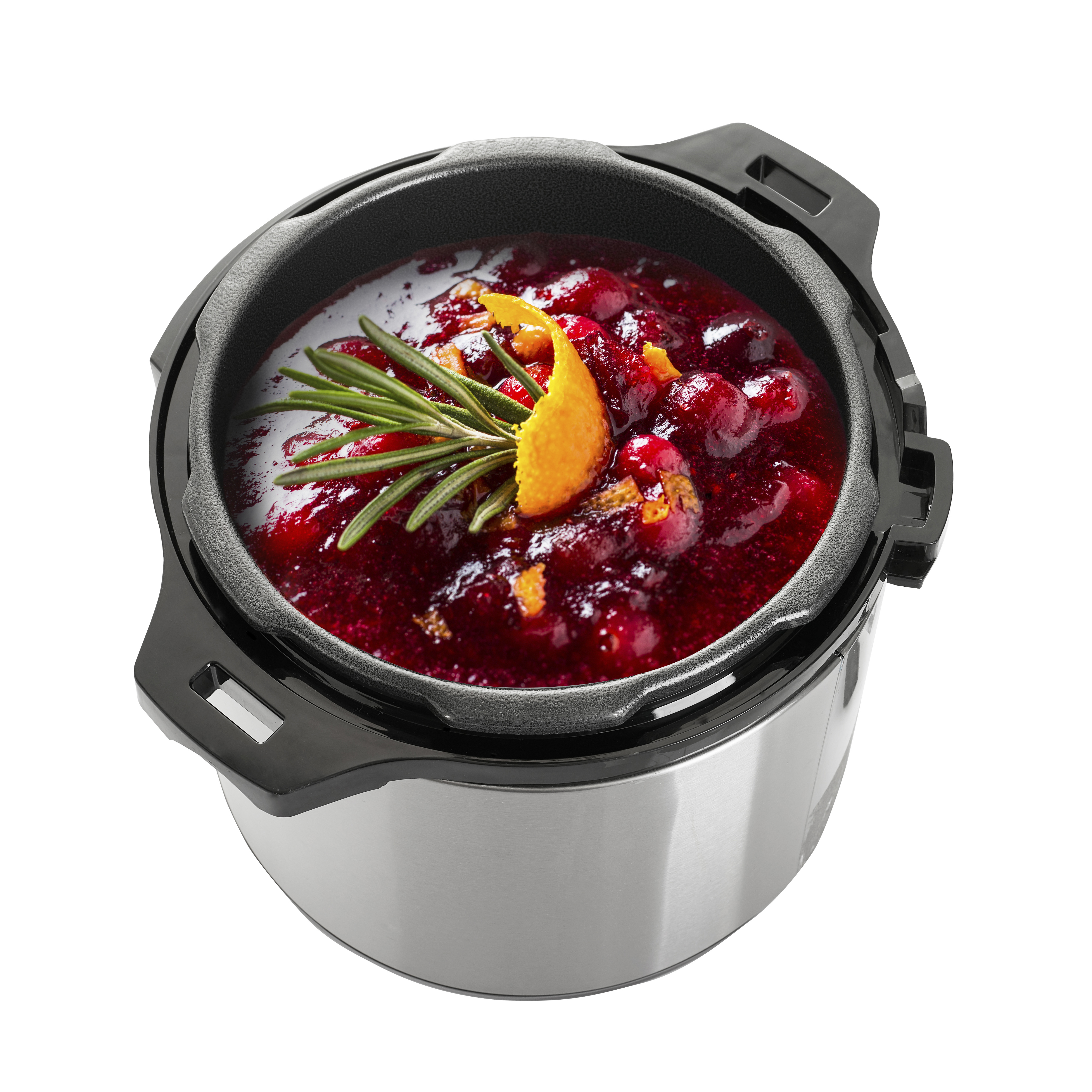 Una olla de cocción lenta con salsa de arándanos, adornada con romero y cáscara de naranja.