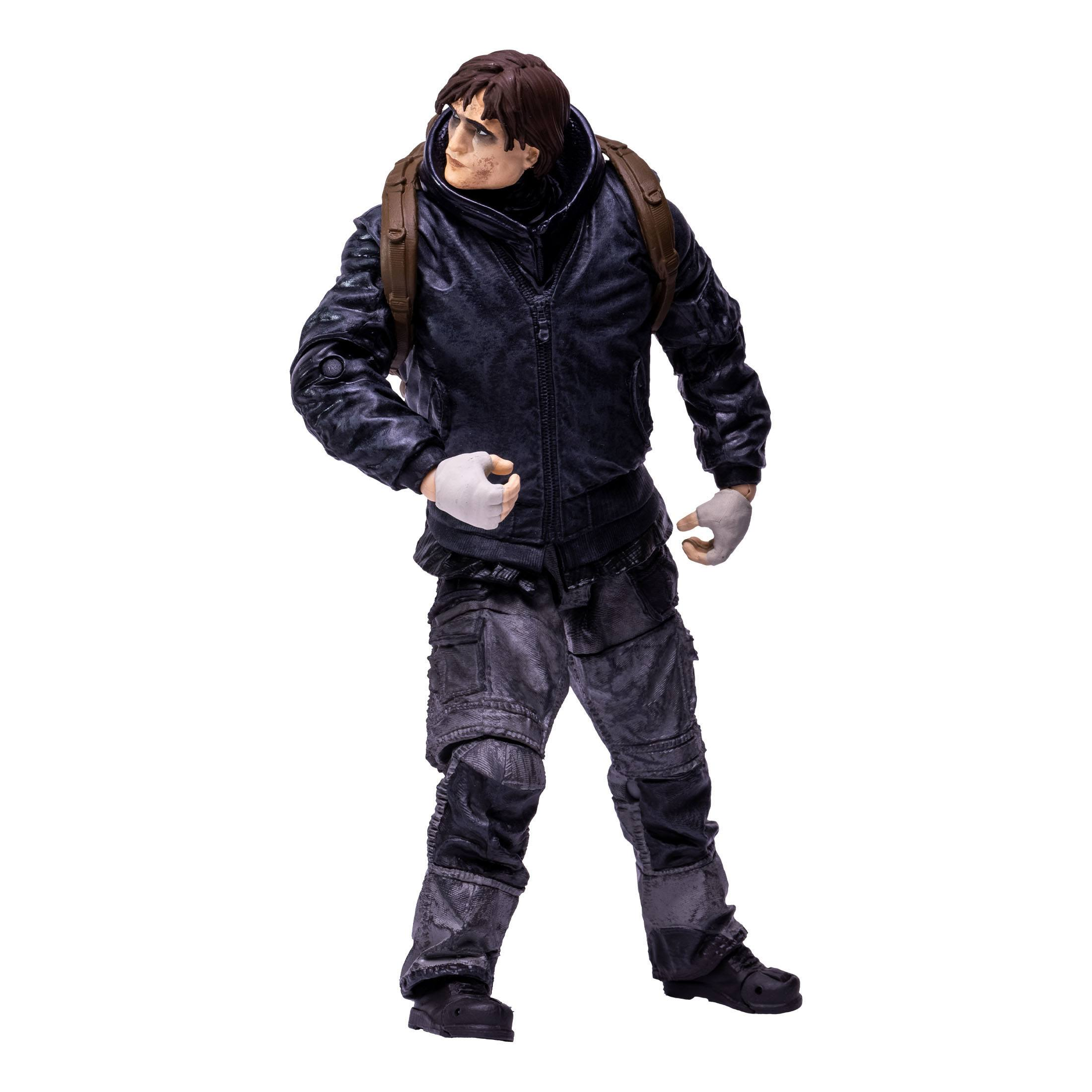 Eine Figur eines Mannes in Wintermantel und Hose mit Rucksack, vor weißem Hintergrund.