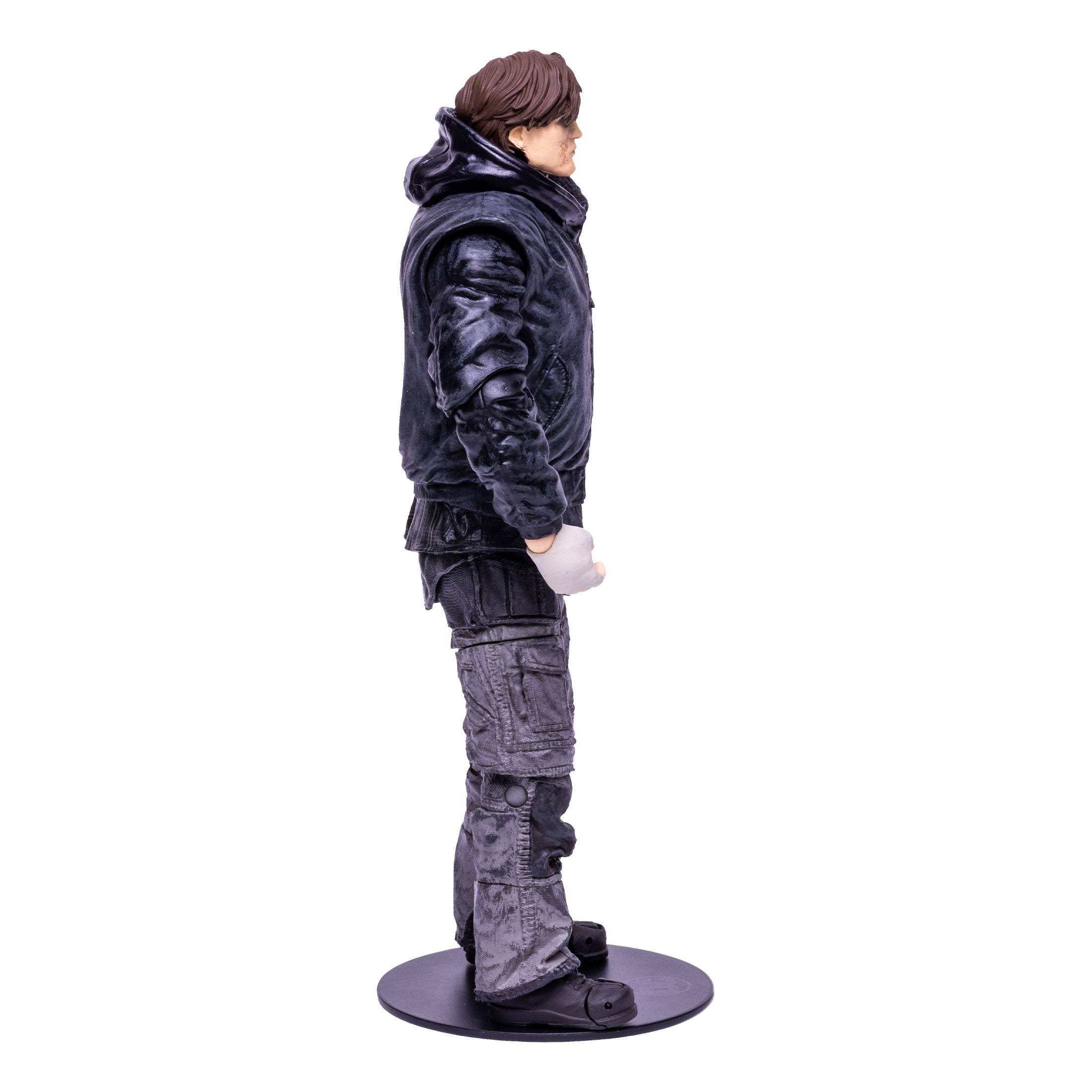 Seitenansicht einer männlichen Actionfigur. Er trägt schwarze Kleidung und steht auf schwarzem Sockel.