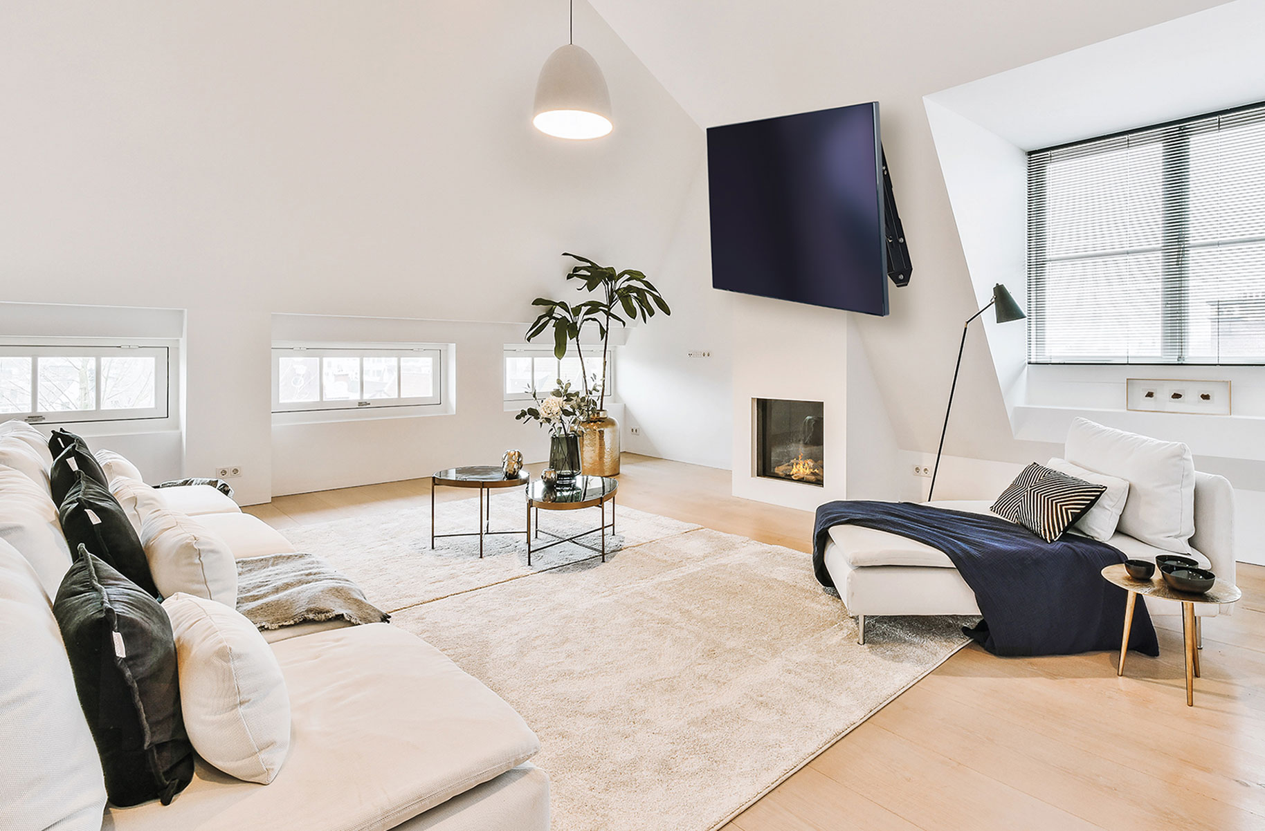 Una sala de estar moderna. Un televisor grande, muebles blancos y una alfombra clara.