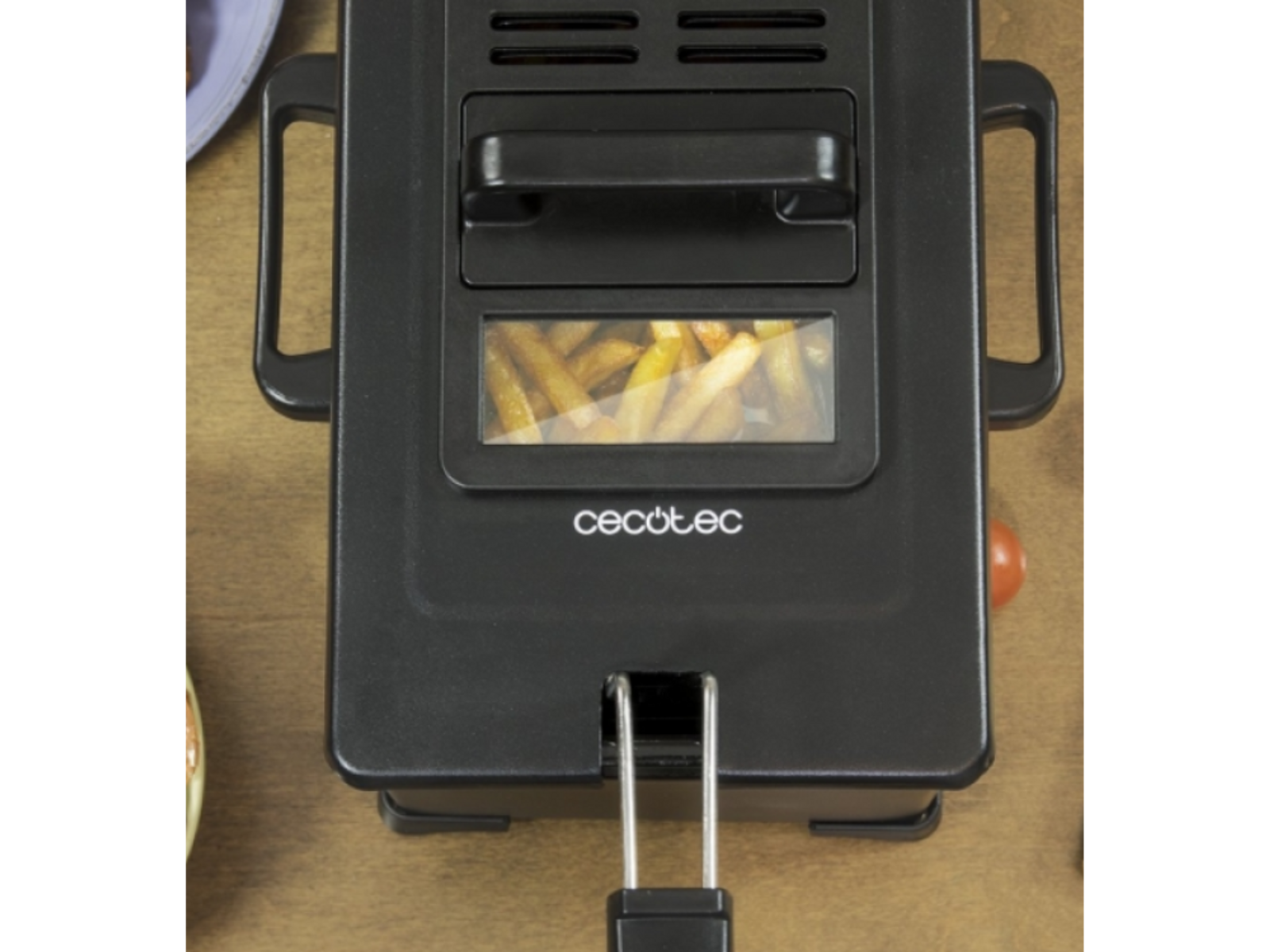 Czarna frytownica beztłuszczowa Cecotec z widocznymi frytkami w środku.