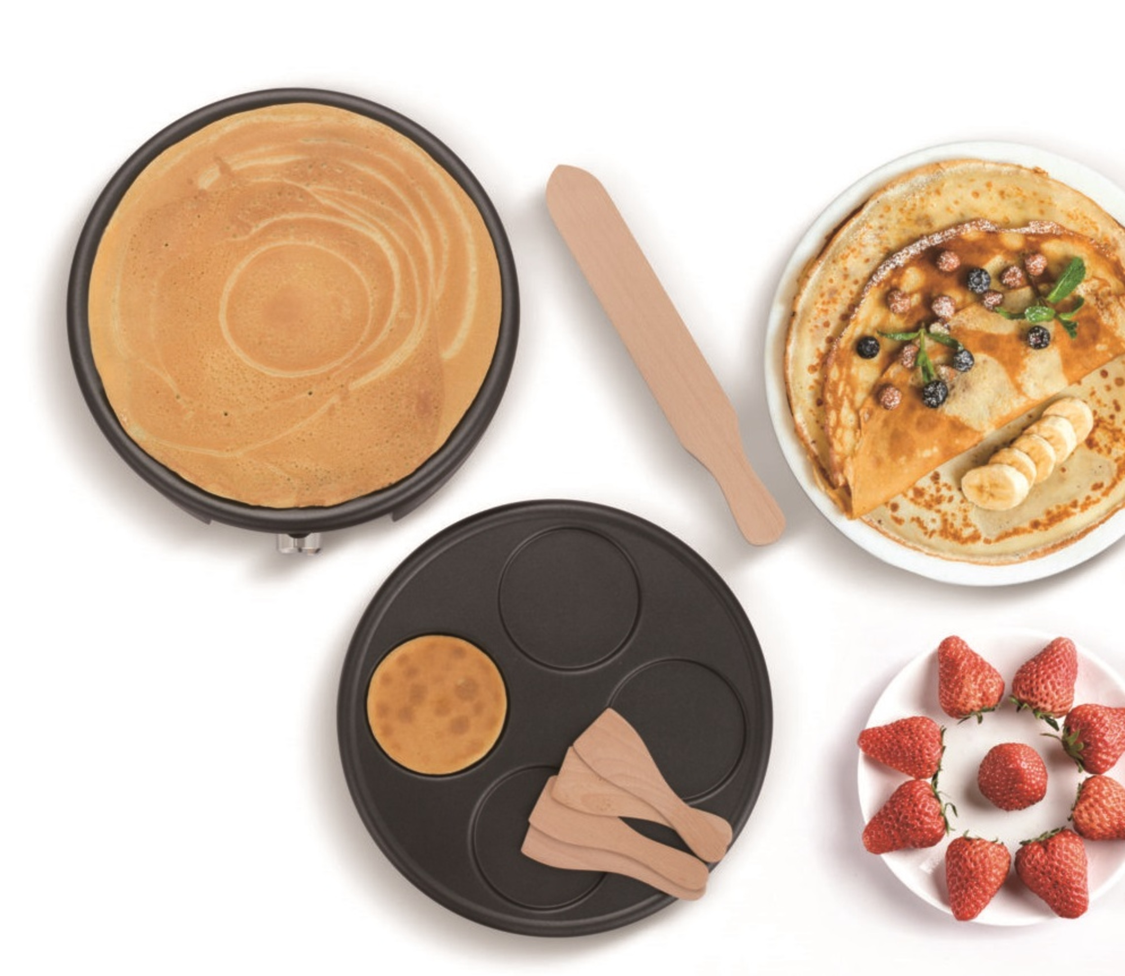 Pfannkuchen-Maker mit Pfannkuchen und Erdbeeren. Ein Teller mit Pfannkuchen mit Obst.