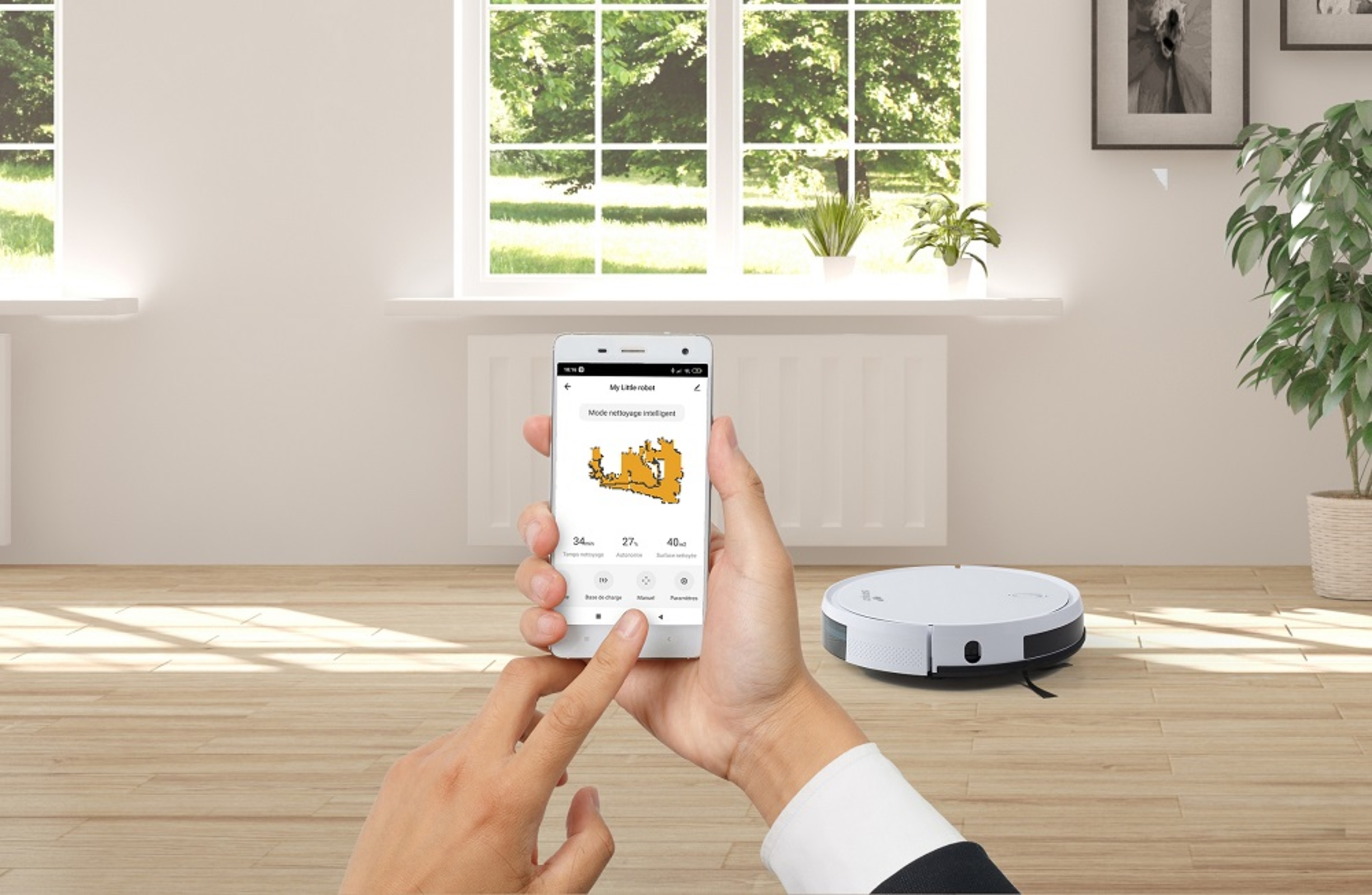 Hände halten ein Telefon, das eine Karte mit einem Roboter-Staubsauger auf dem Boden zeigt. Fenster und Pflanze sichtbar.