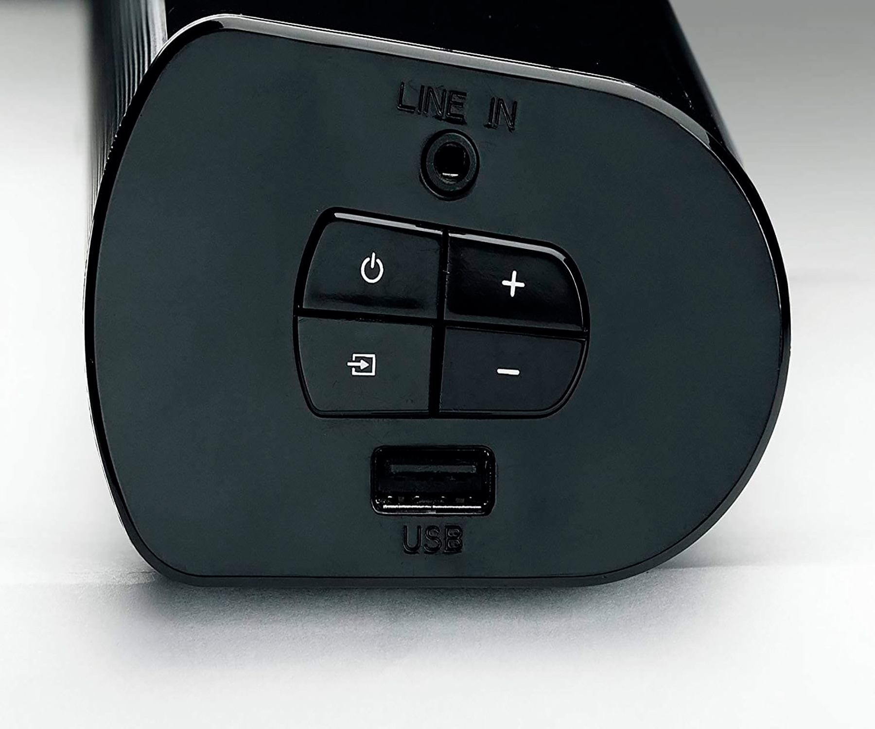 Barra de sonido negra con botones de encendido, volumen y entrada, y puerto USB.
