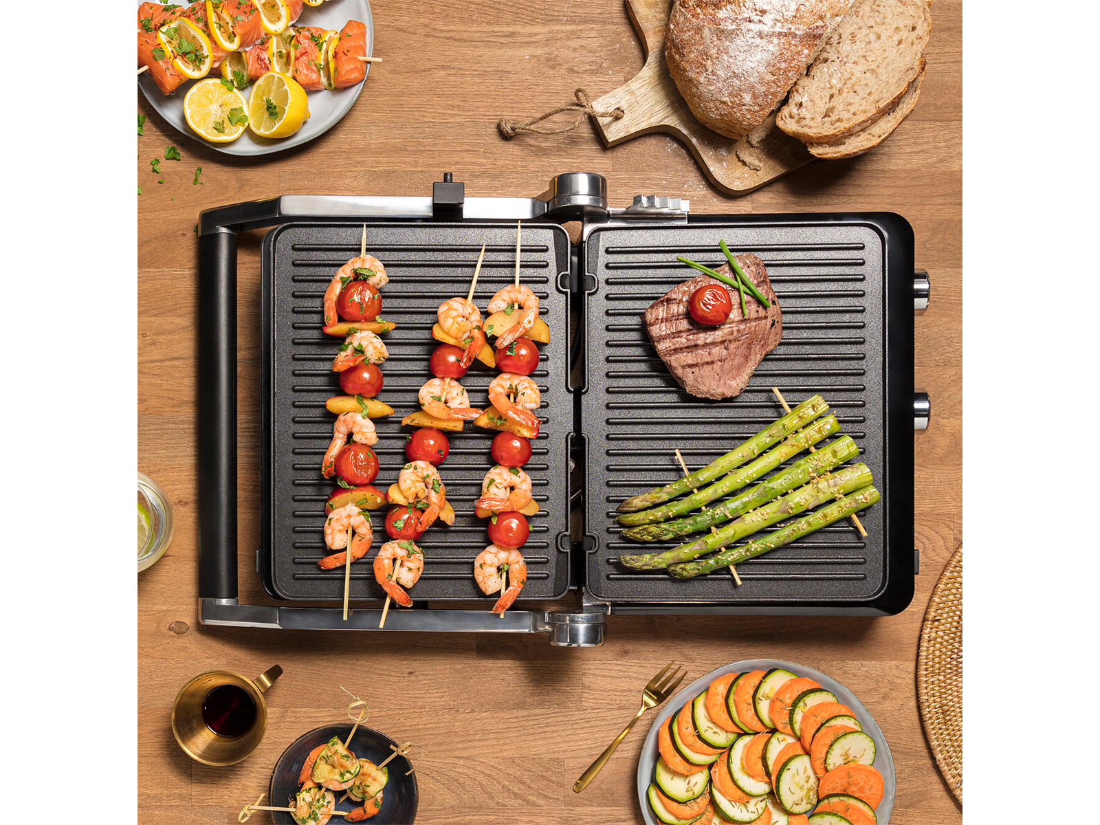 Grill mit Garnesspießen, Steak und Gemüse. Holztisch.