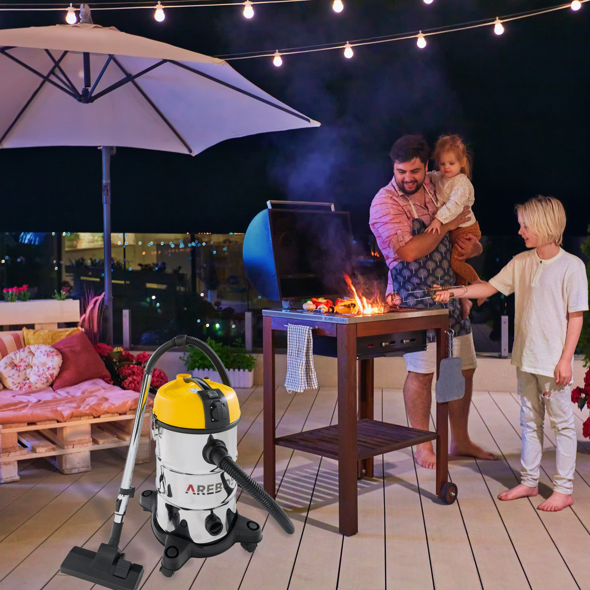 Familien-BBQ auf der Terrasse. Mann grillt, Frau hält Kind, Junge schaut zu. Staubsauger sichtbar.