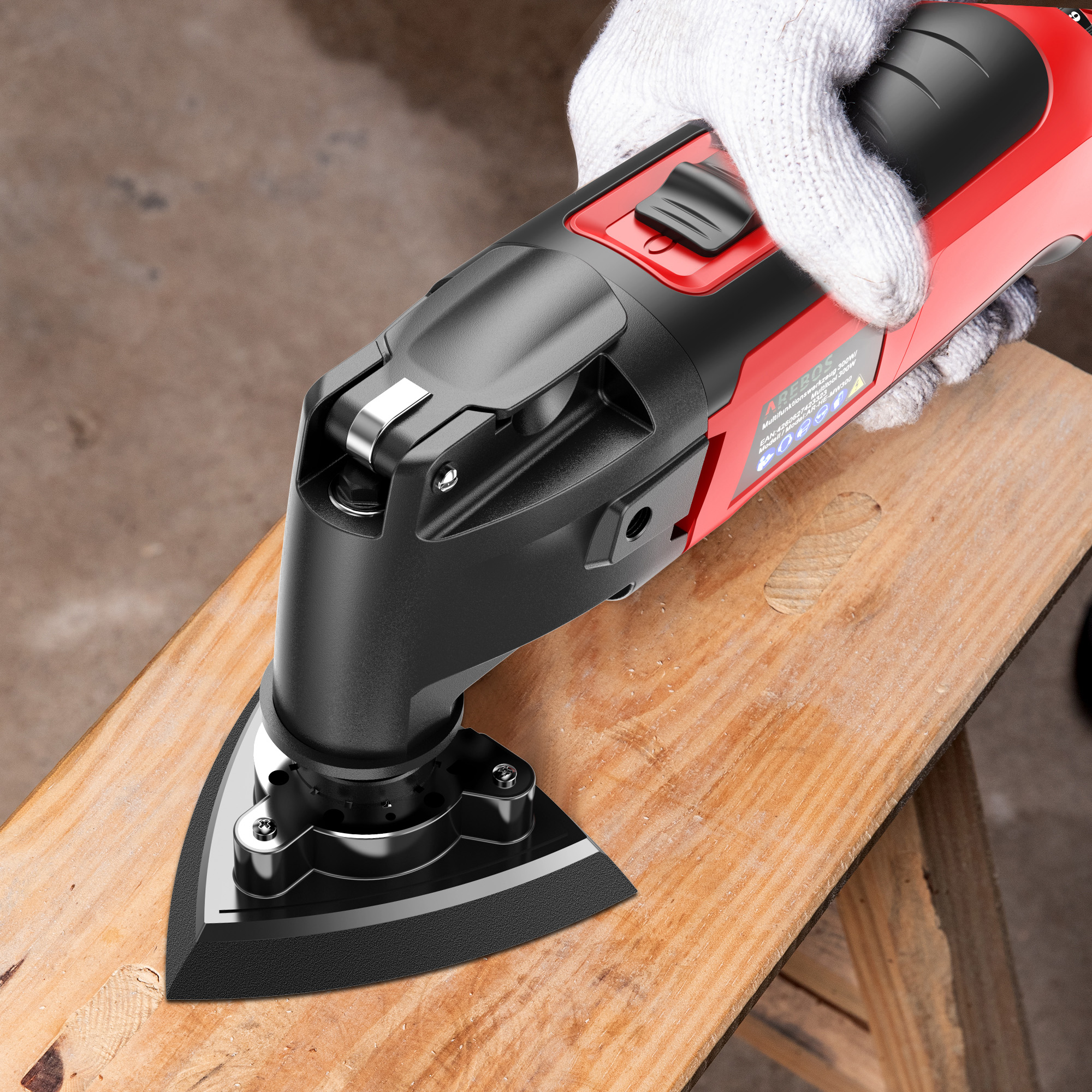 Eine behandschuhte Hand hält ein rot-schwarzes Multitool über einem Holzbrett. Das Werkzeug soll das Holz schneiden.