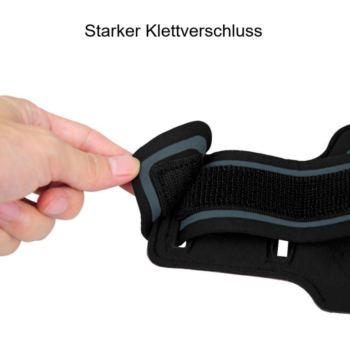 Hand hält einen schwarzen Riemen und zeigt einen Klettverschluss.