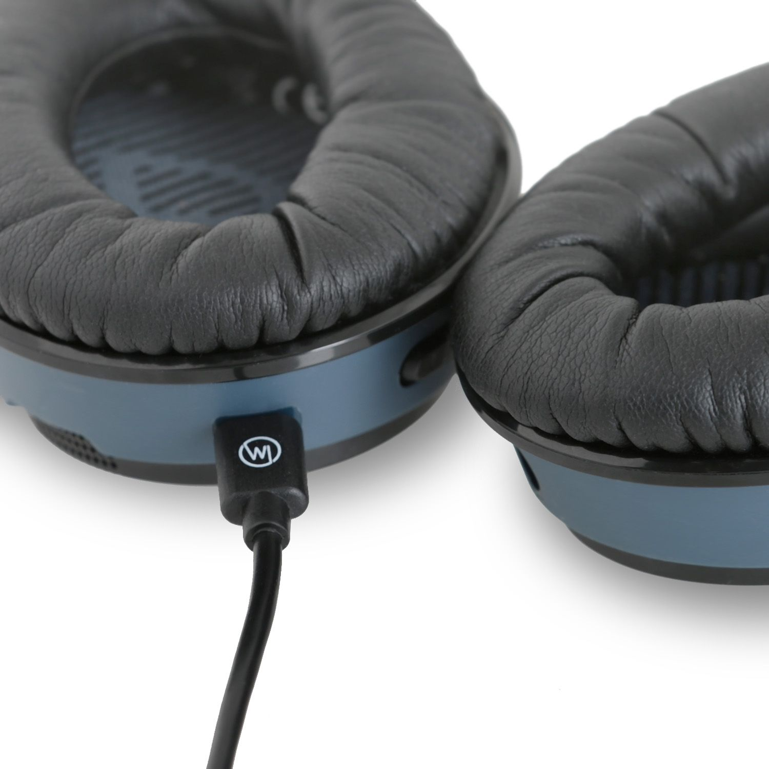 Nahaufnahme von Kopfhörern mit schwarzen Ohrmuscheln und einem angeschlossenen schwarzen Kabel.