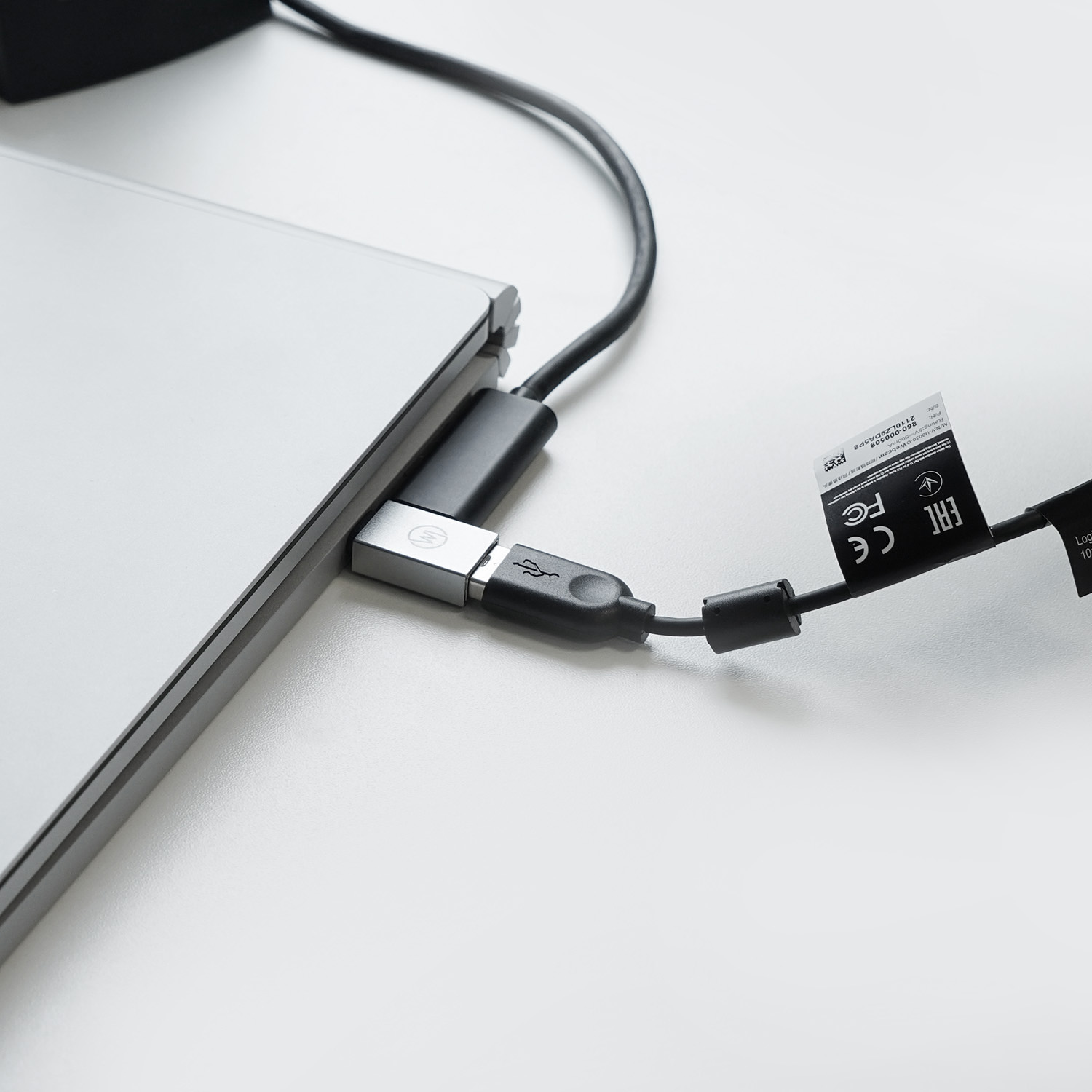 Schwarzes USB-Kabel, das an einen Laptop angeschlossen ist. Das Kabel ist eingesteckt.