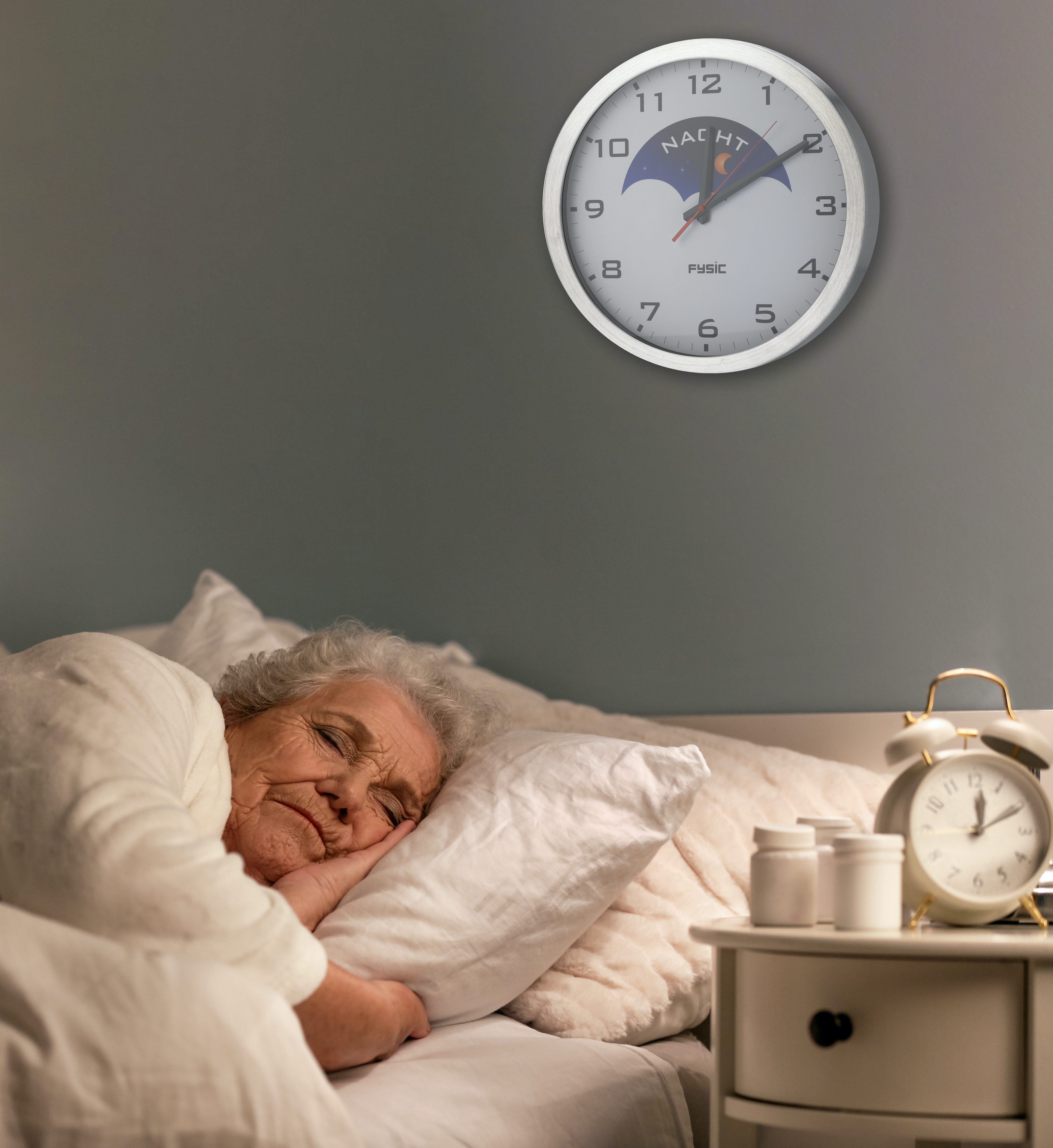 Ältere Frau schläft im Bett, mit Wecker und Uhr auf dem Nachttisch, Nachtszene.