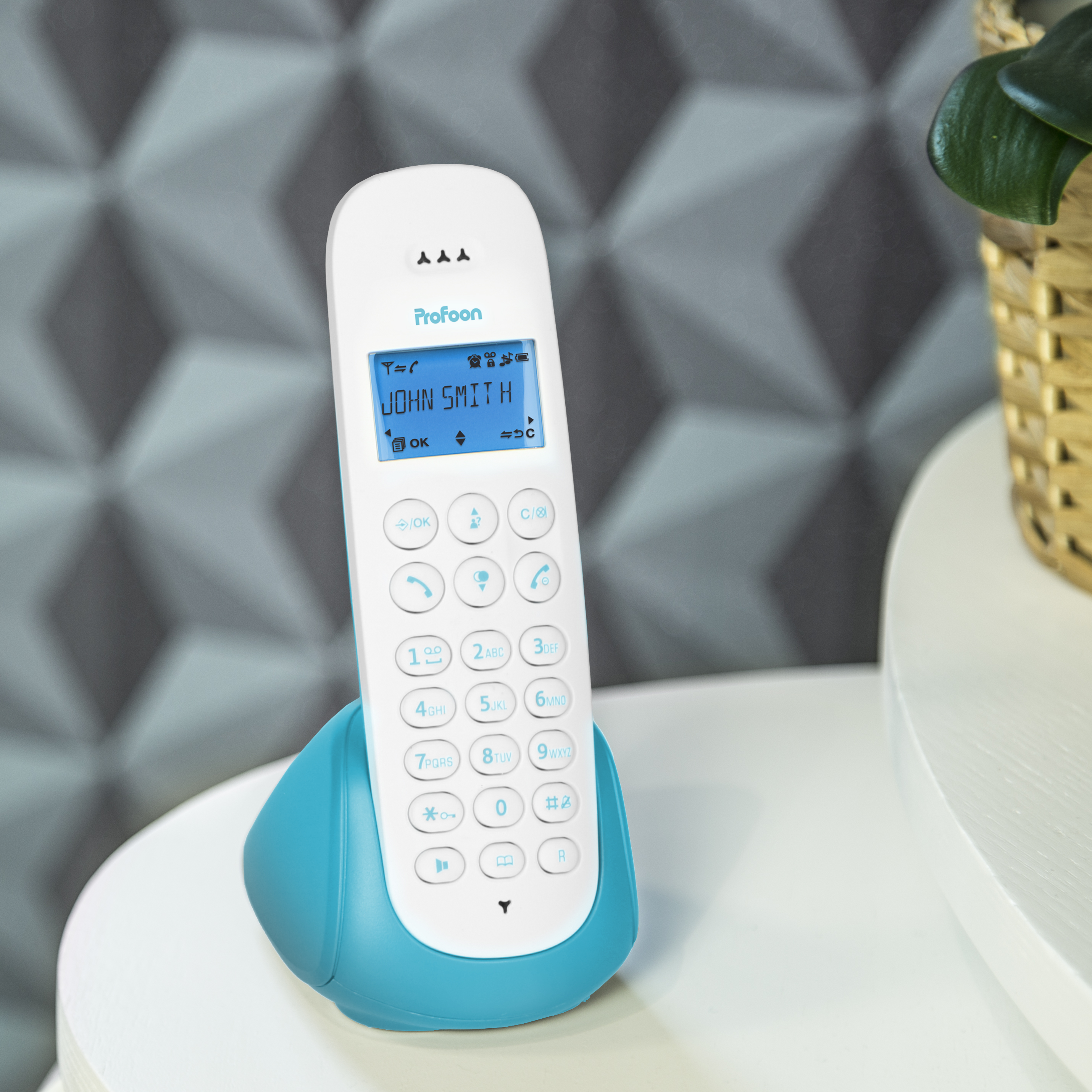 Un telefono cordless bianco e verde acqua con uno schermo che mostra 'JOHN SMITH'.