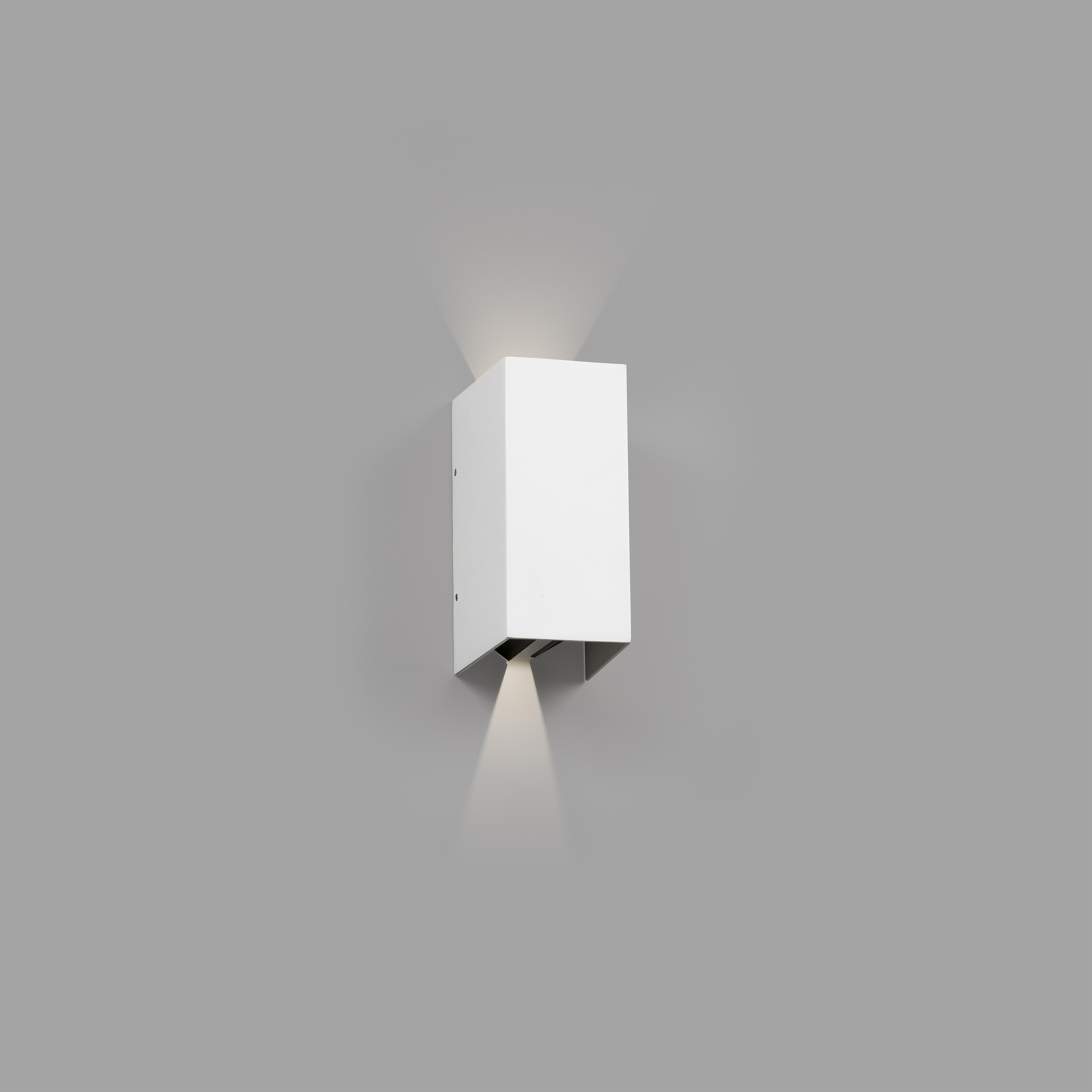 Un'apparecchio per illuminazione a parete bianco che emette luce verso l'alto e verso il basso. Sfondo grigio.