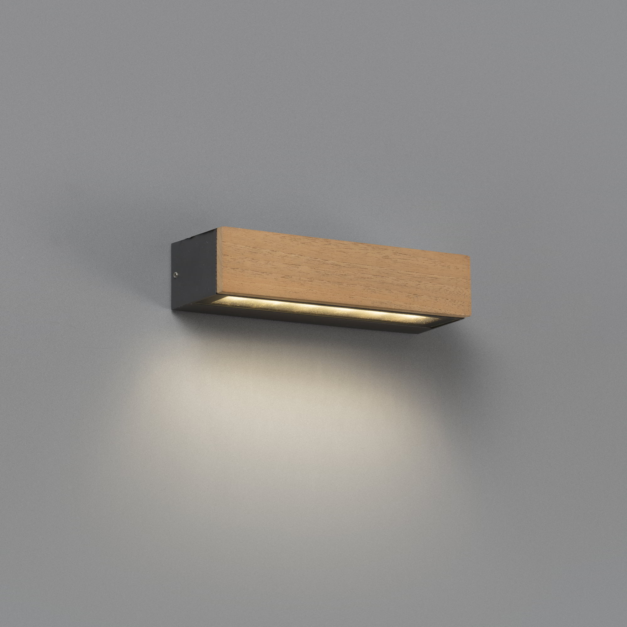 Una lampada rettangolare in legno è montata su un muro grigio, che emette una luce soffusa verso il basso.