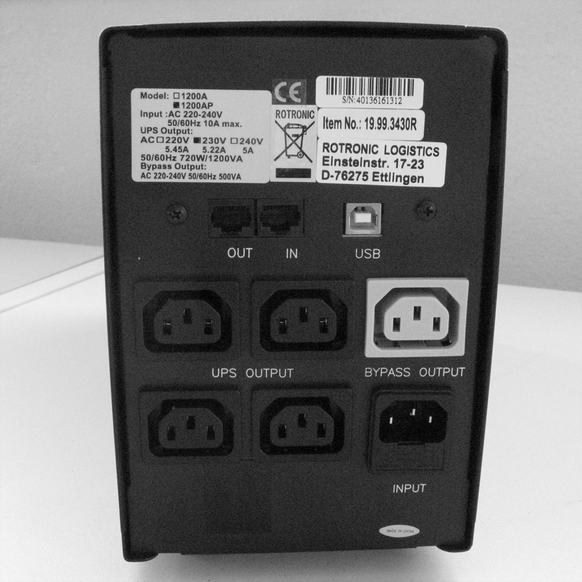 Schwarze USV mit mehreren Ausgangsanschlüssen und einem USB-Anschluss. Etiketten liefern technische Daten.