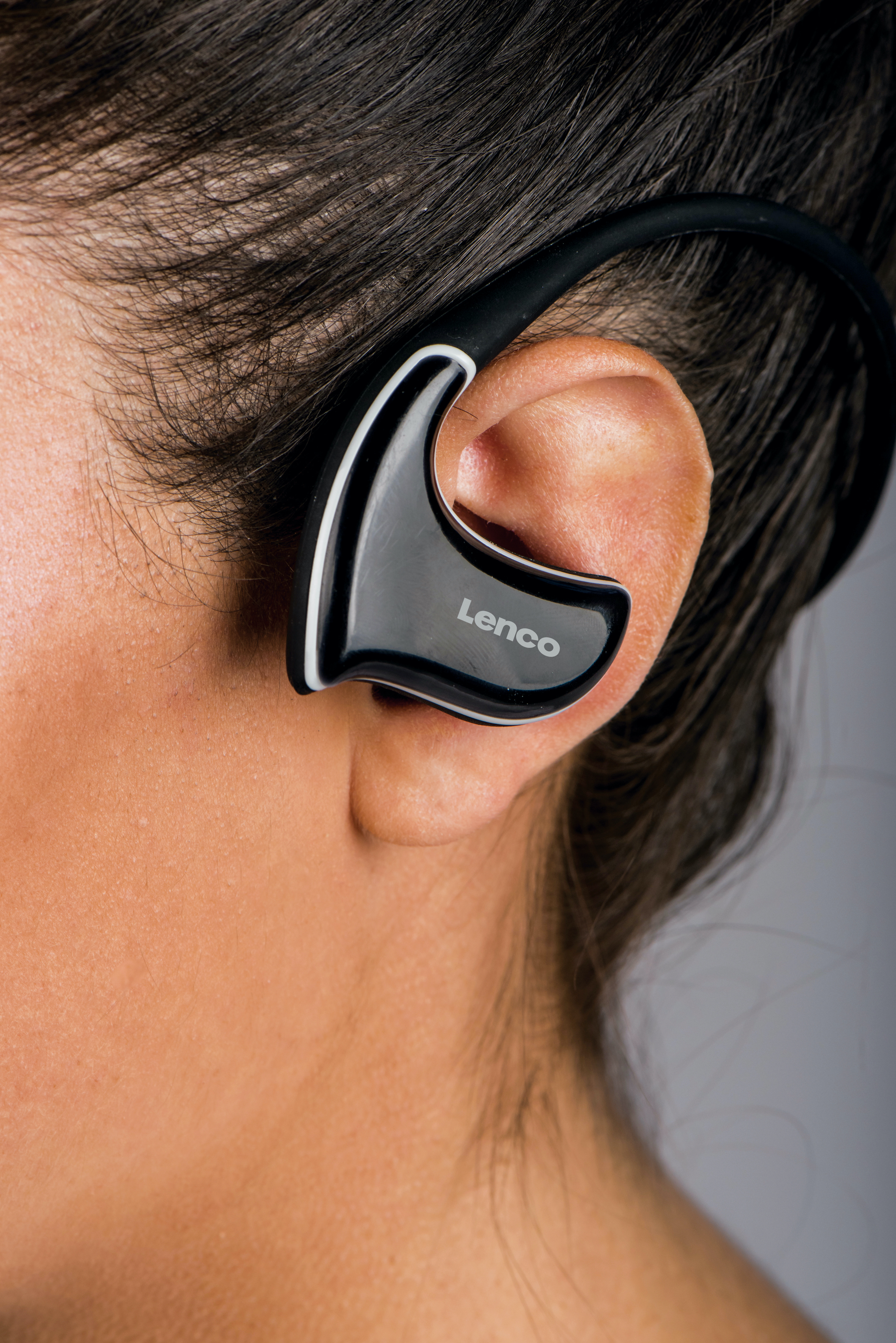 Una persona che indossa un auricolare Bluetooth Lenco nero e argento nel suo orecchio.