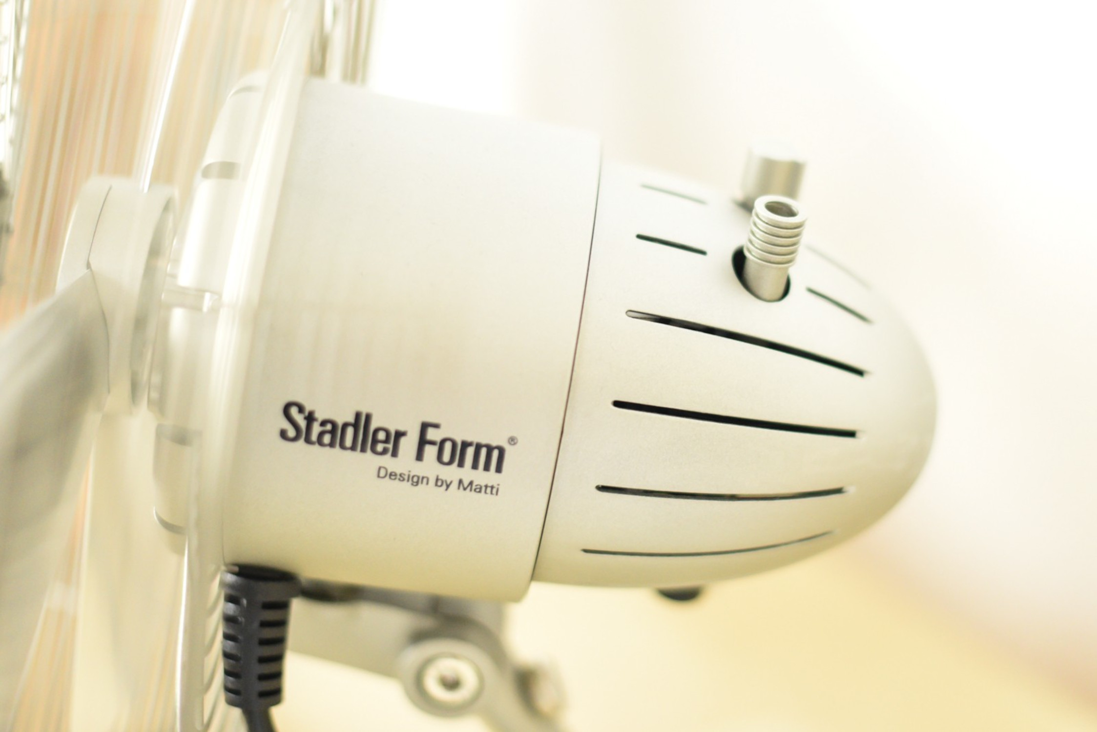 Close-up of a Stadler Form fan motor. The motor is white with the brand name on it.