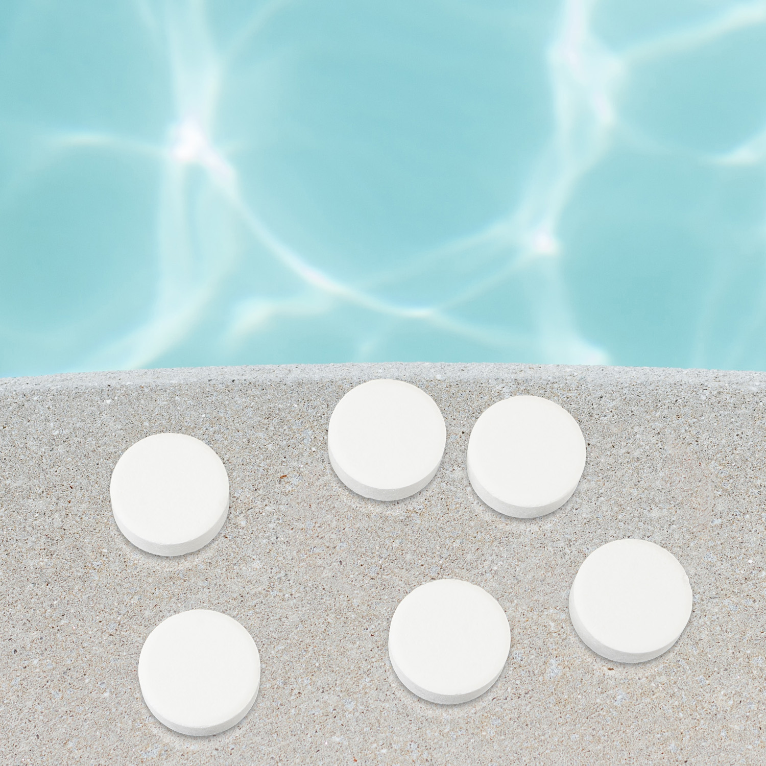 Sechs weiße Pooltabletten auf grauer Betonoberfläche, mit blauem Poolwasser im Hintergrund.