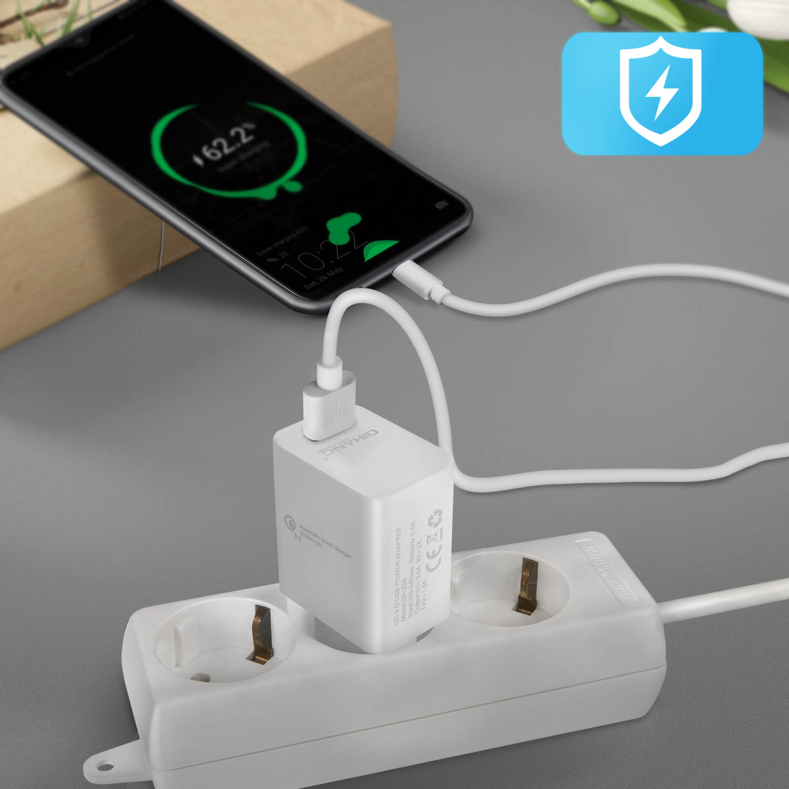 Telefon lädt mit weißem Adapter, der an eine Steckdose angeschlossen ist.