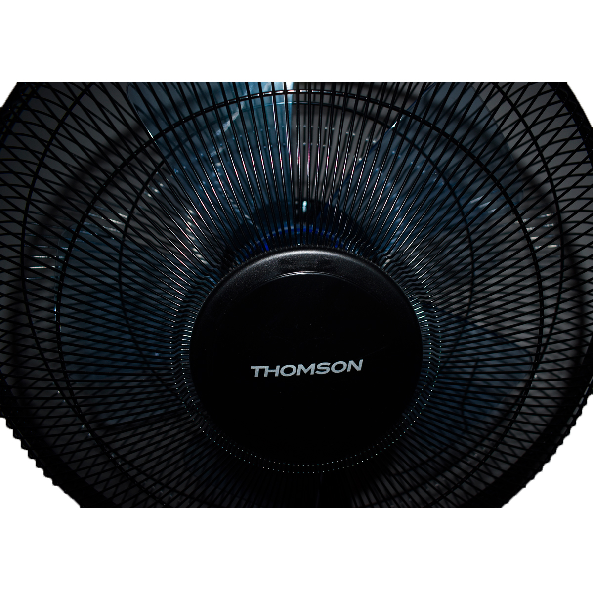 Un ventilador oscilante negro con una jaula. El ventilador tiene el nombre Thomson.