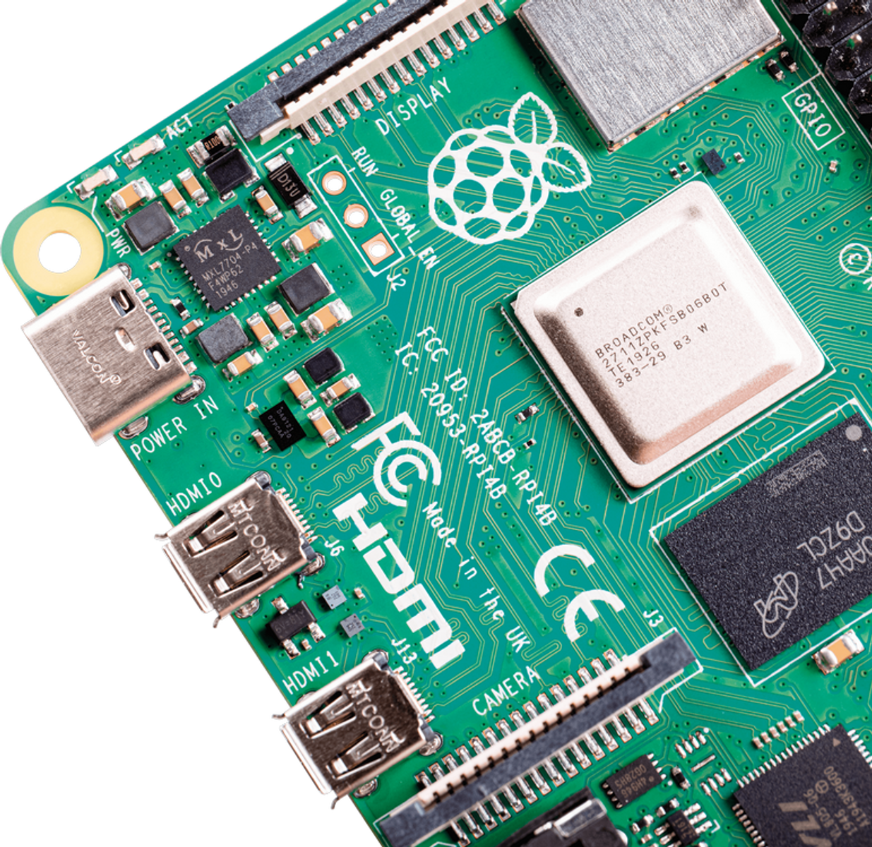 Primer plano de una placa de circuito verde con chips, conectores y el logo de Raspberry Pi.