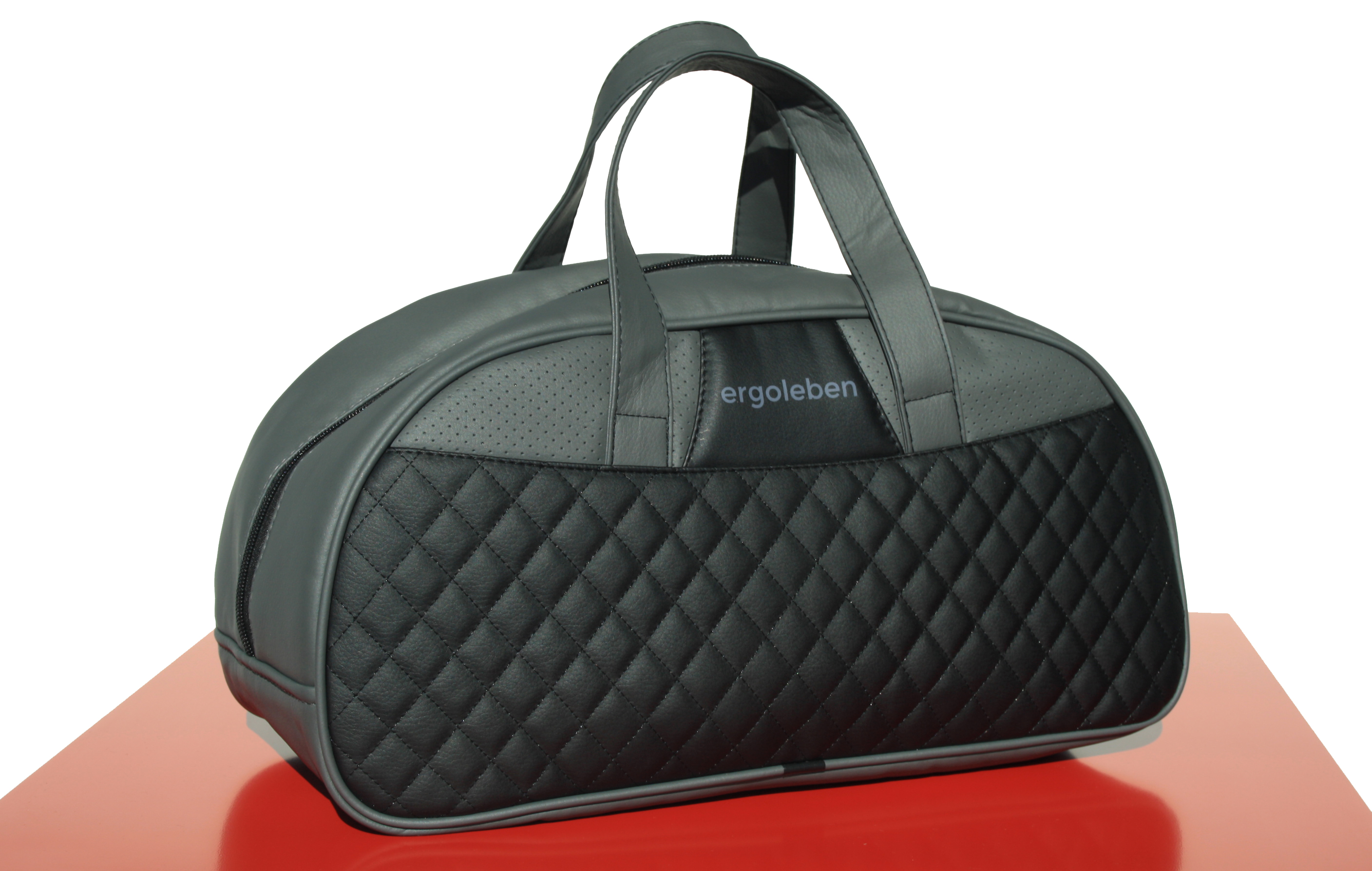 Eine grau-schwarze Sporttasche mit der Aufschrift 'ergoleben'. Die Tasche liegt auf rotem Grund.