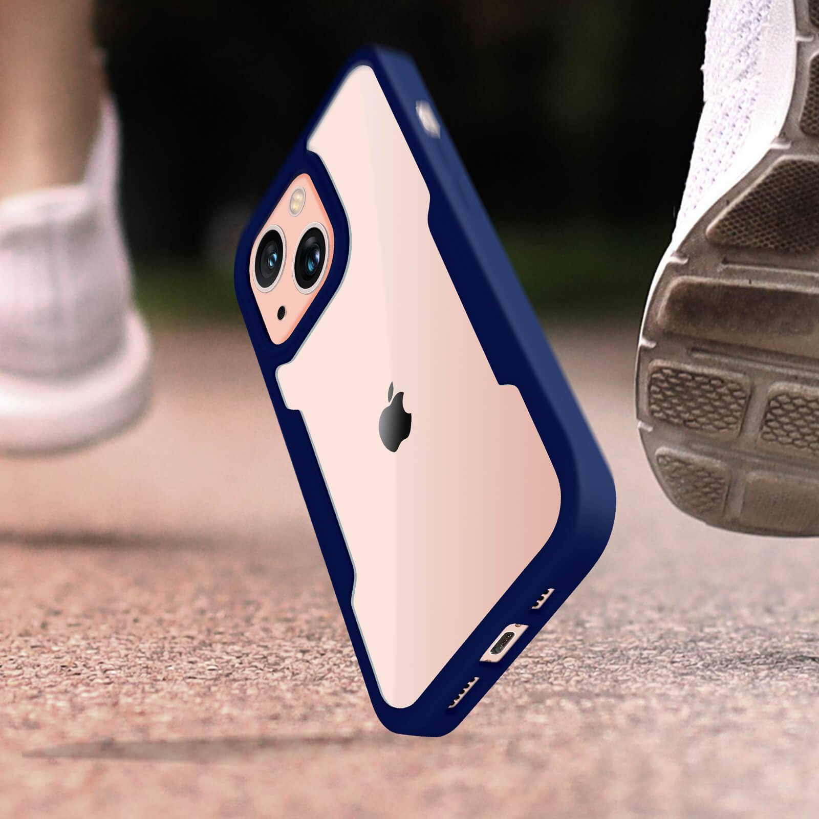 Un étui de téléphone est sur du béton, avec les jambes et les chaussures d'une personne en arrière-plan.