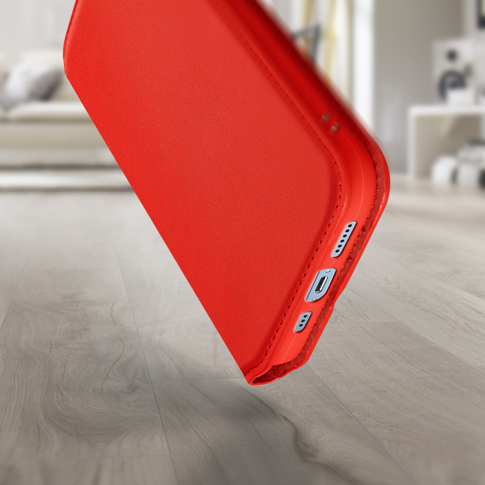Coque de téléphone rouge sur une surface en bois. Montre les boutons latéraux, le port de charge et une découpe pour la caméra.