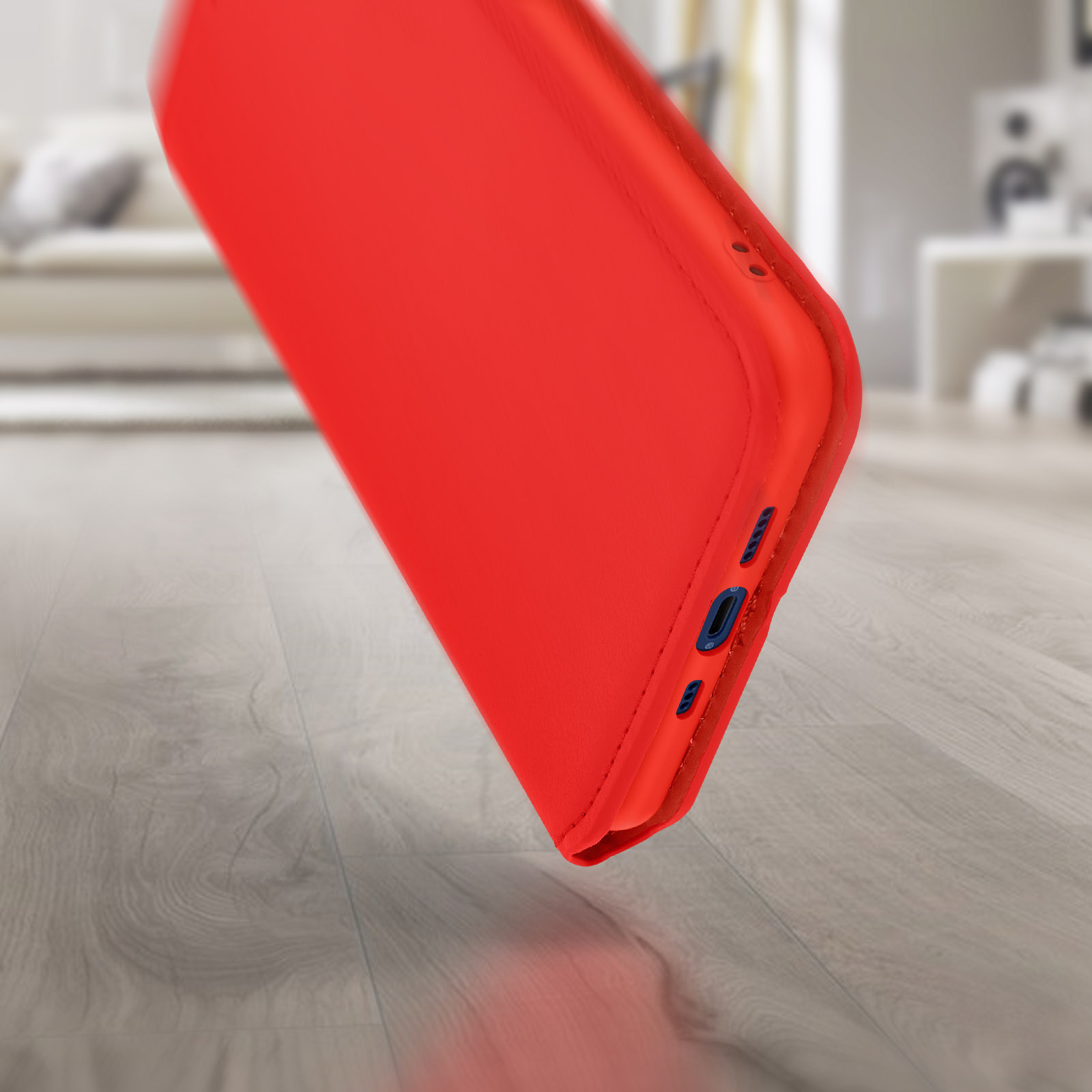 Een rode telefoonhoes in een hoek, met de onderrand met blauwe knoppen en poorten.