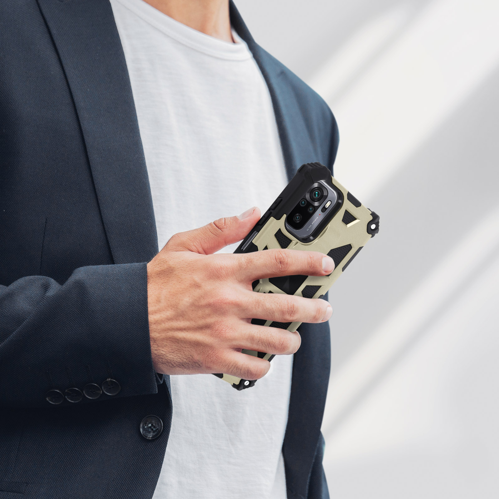 Mann hält ein Telefon mit gemusterter Hülle. Er trägt einen Anzug.