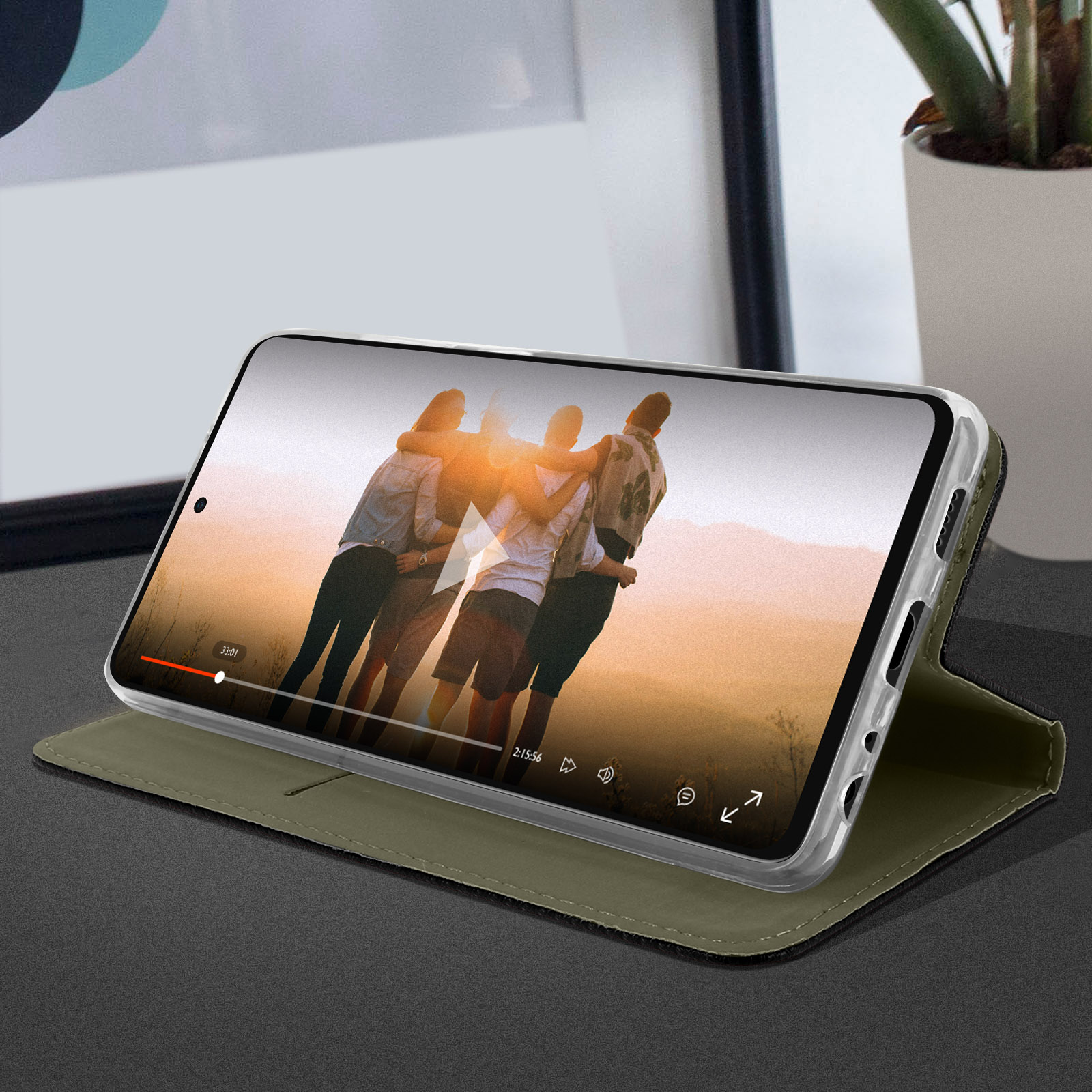 Uno smartphone mostra un video. Il telefono è in una custodia su una superficie scura.