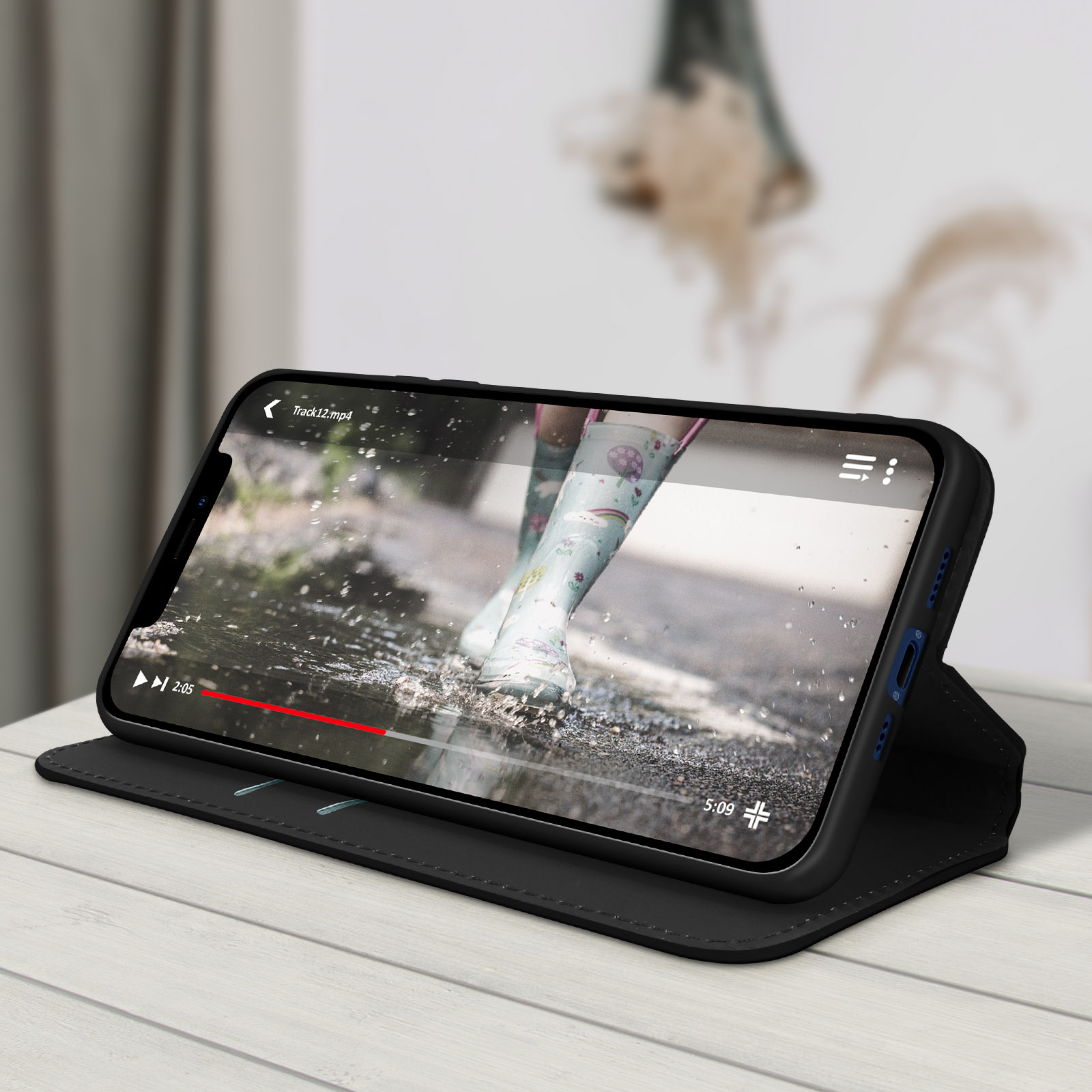 Een smartphone in een zwarte hoes die een video afspeelt van iemand die op een nat oppervlak loopt.