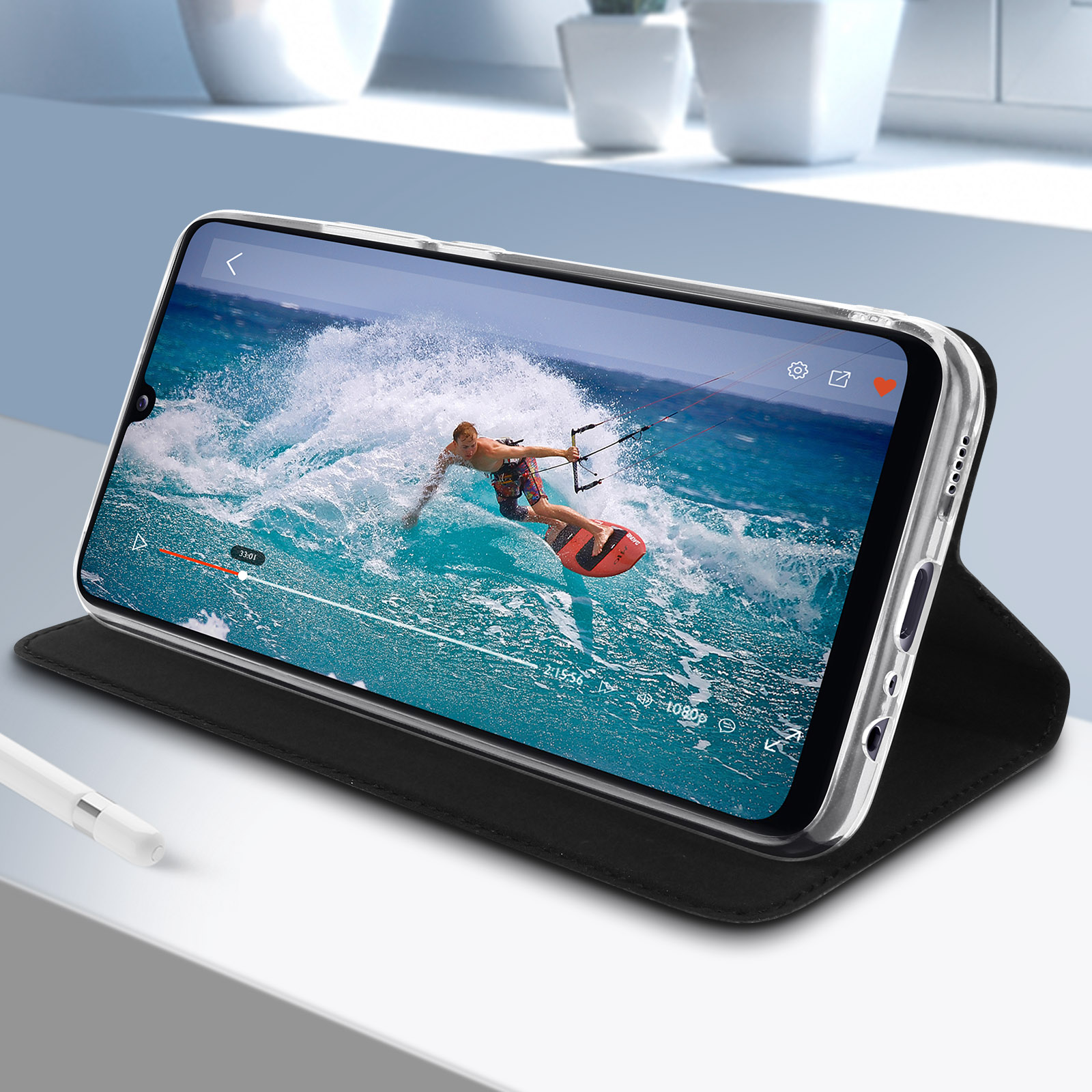 Smartphone che mostra un video di un uomo che fa kitesurf, mostrato in una custodia nera con una copertura nera.