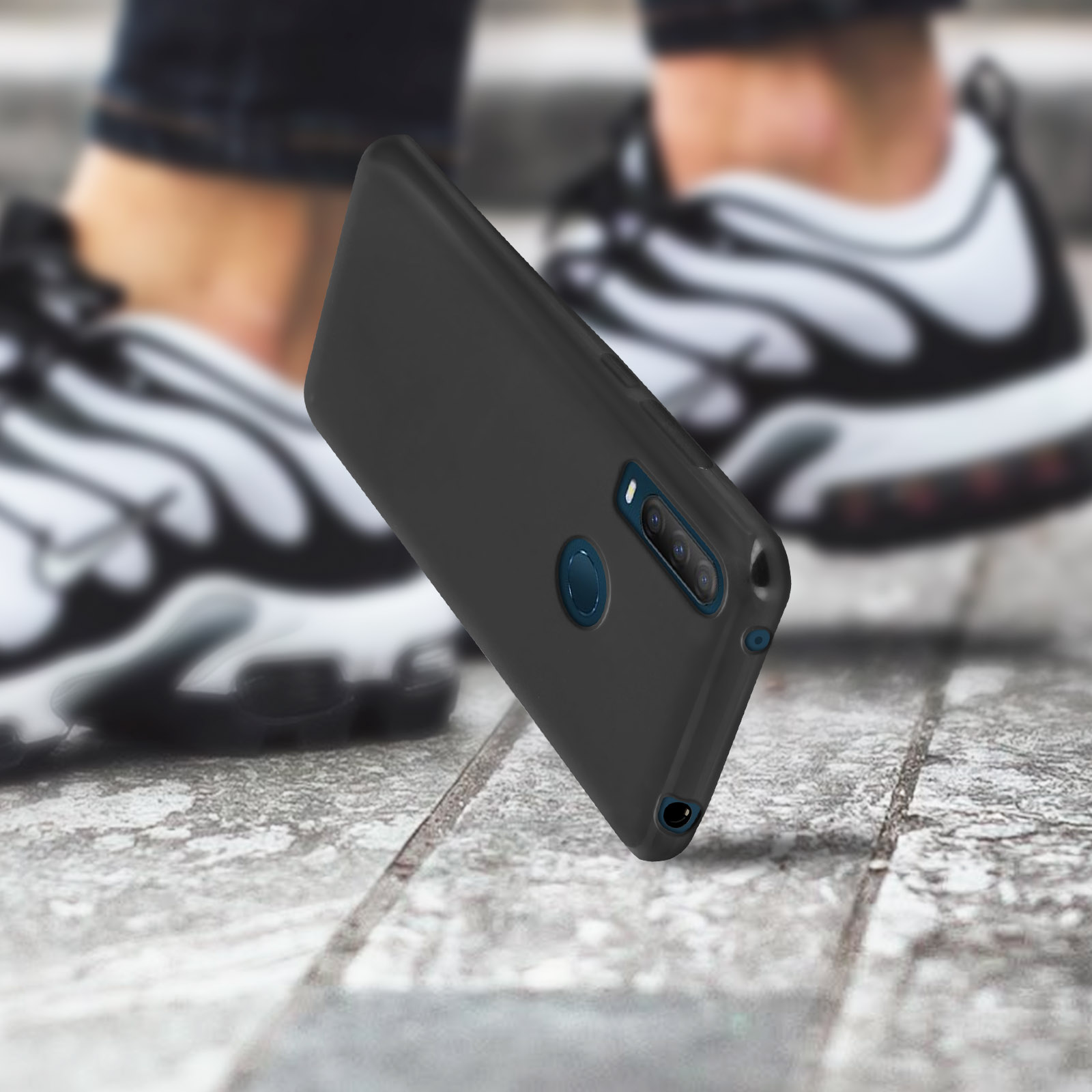 Coque de téléphone noire avec cercle de caméra bleu, posée sur une surface texturée.