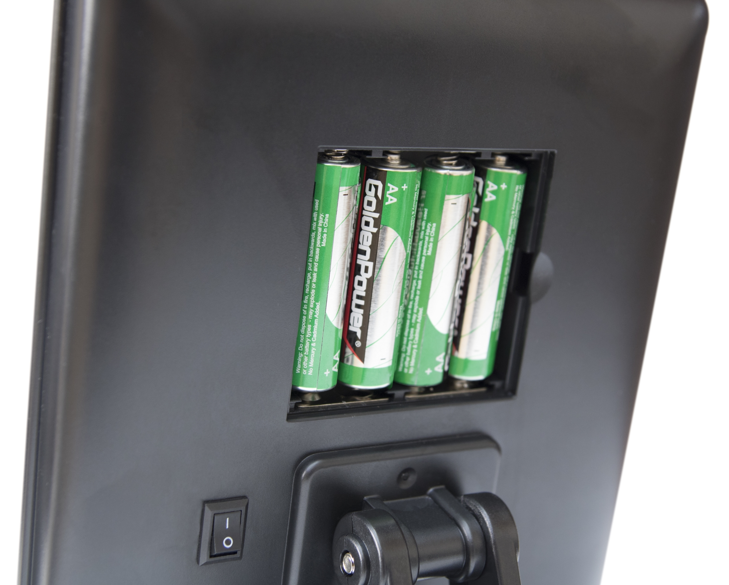 Die Rückseite eines schwarzen Geräts mit offenem Fach, das vier grüne AA-Batterien zeigt.