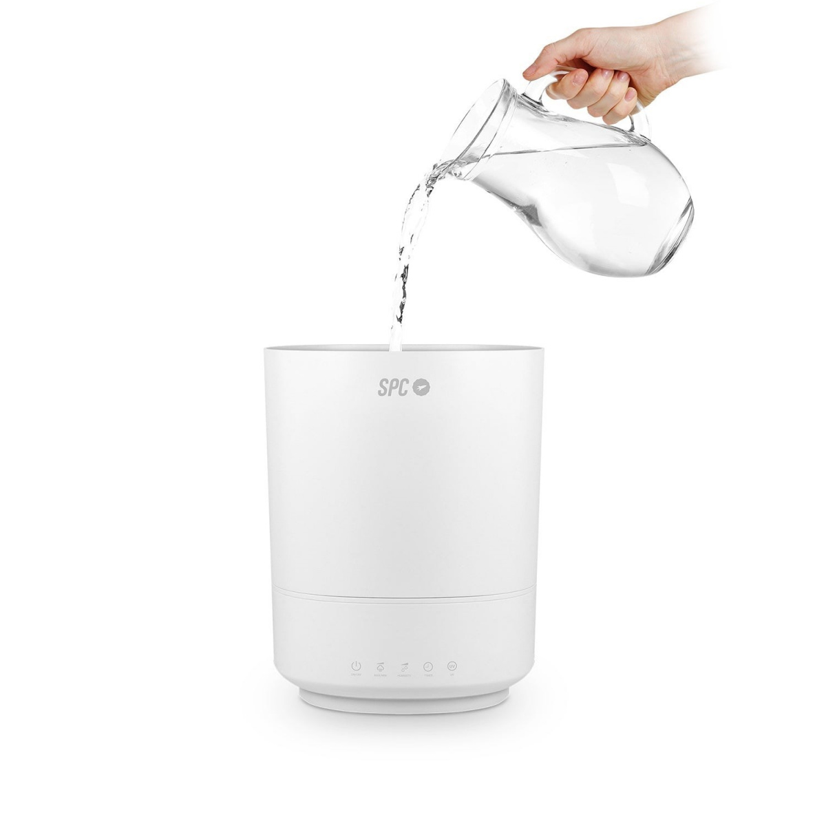 Ręka nalewa wodę z dzbanka do białego nawilżacza.