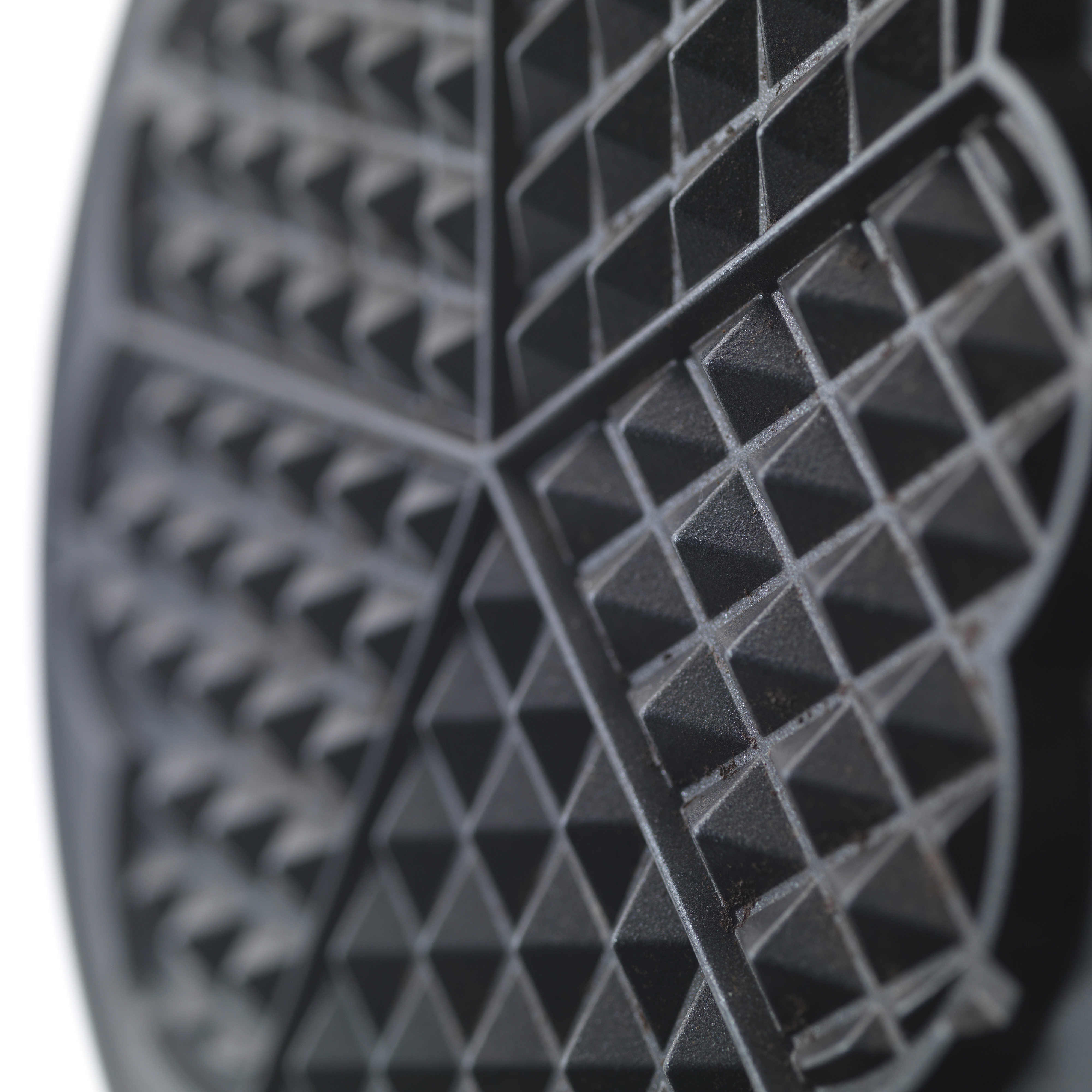 Nahaufnahme eines schwarzen Waffeleisens mit herzförmigem Muster, das das Gitter zeigt.