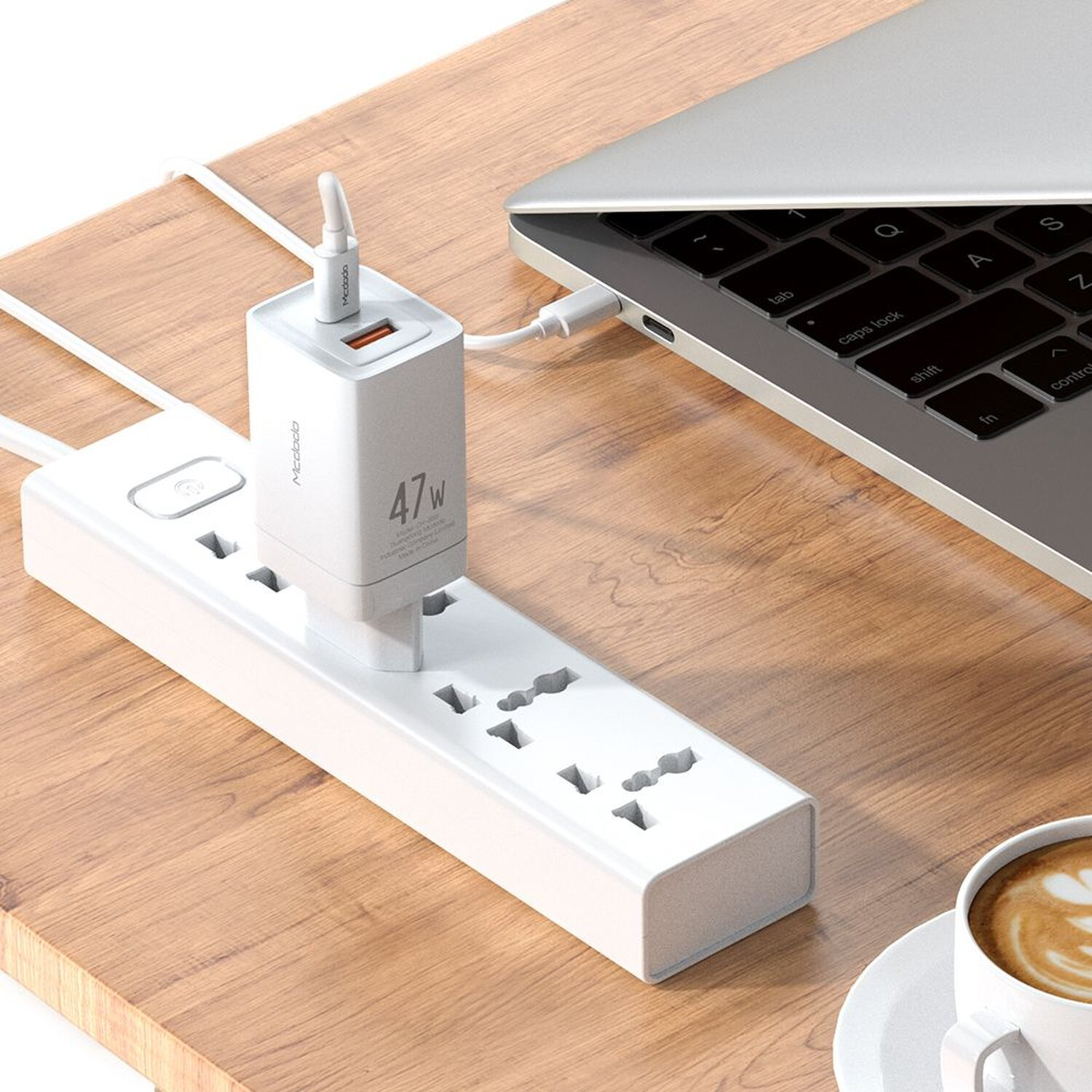 Eine weiße Steckdosenleiste mit einem USB-Ladegerät und einem Laptop, der auf einem Holztisch geladen wird.