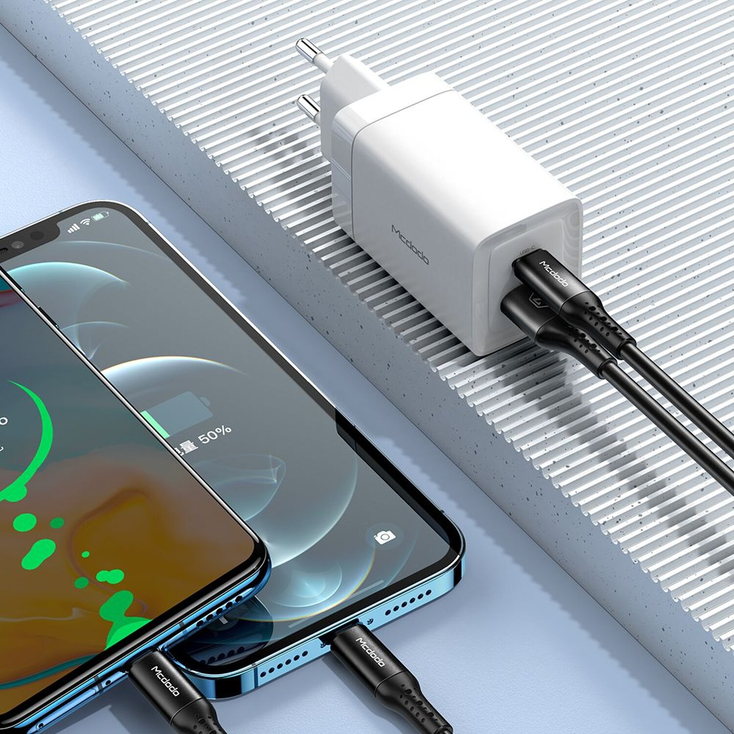 Zwei Telefone, die mit einem Dual-USB-C-Ladegerät aufgeladen werden. Das Ladegerät ist weiß.