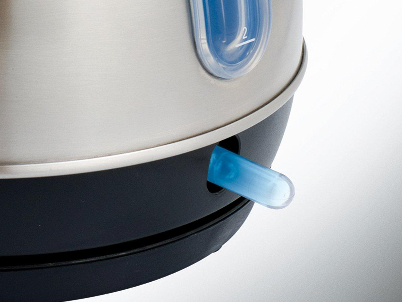 Primo piano di un bollitore argentato con indicatore del livello dell'acqua blu e interruttore blu.