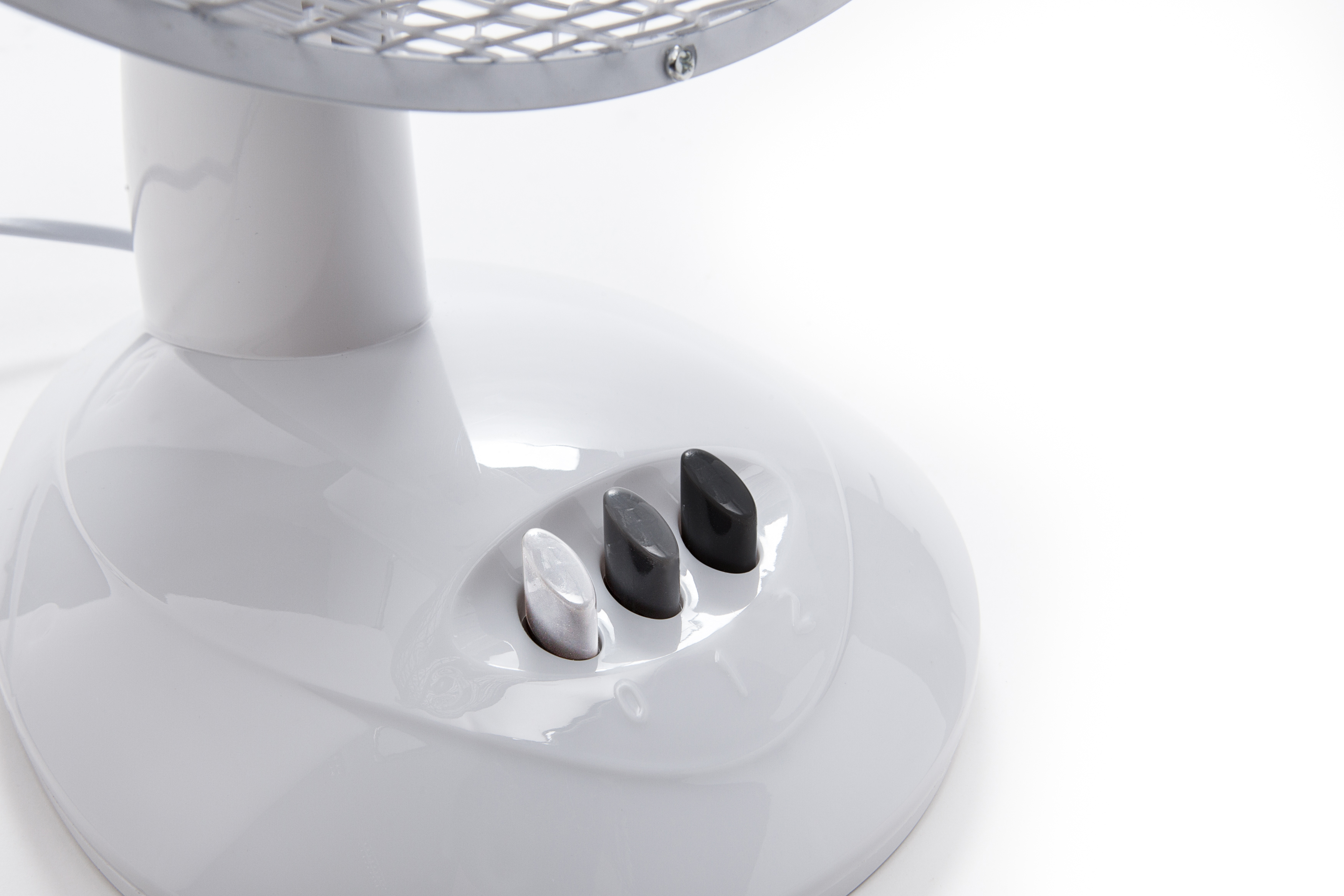 Socle de ventilateur blanc avec trois boutons. Protection argentée au-dessus.