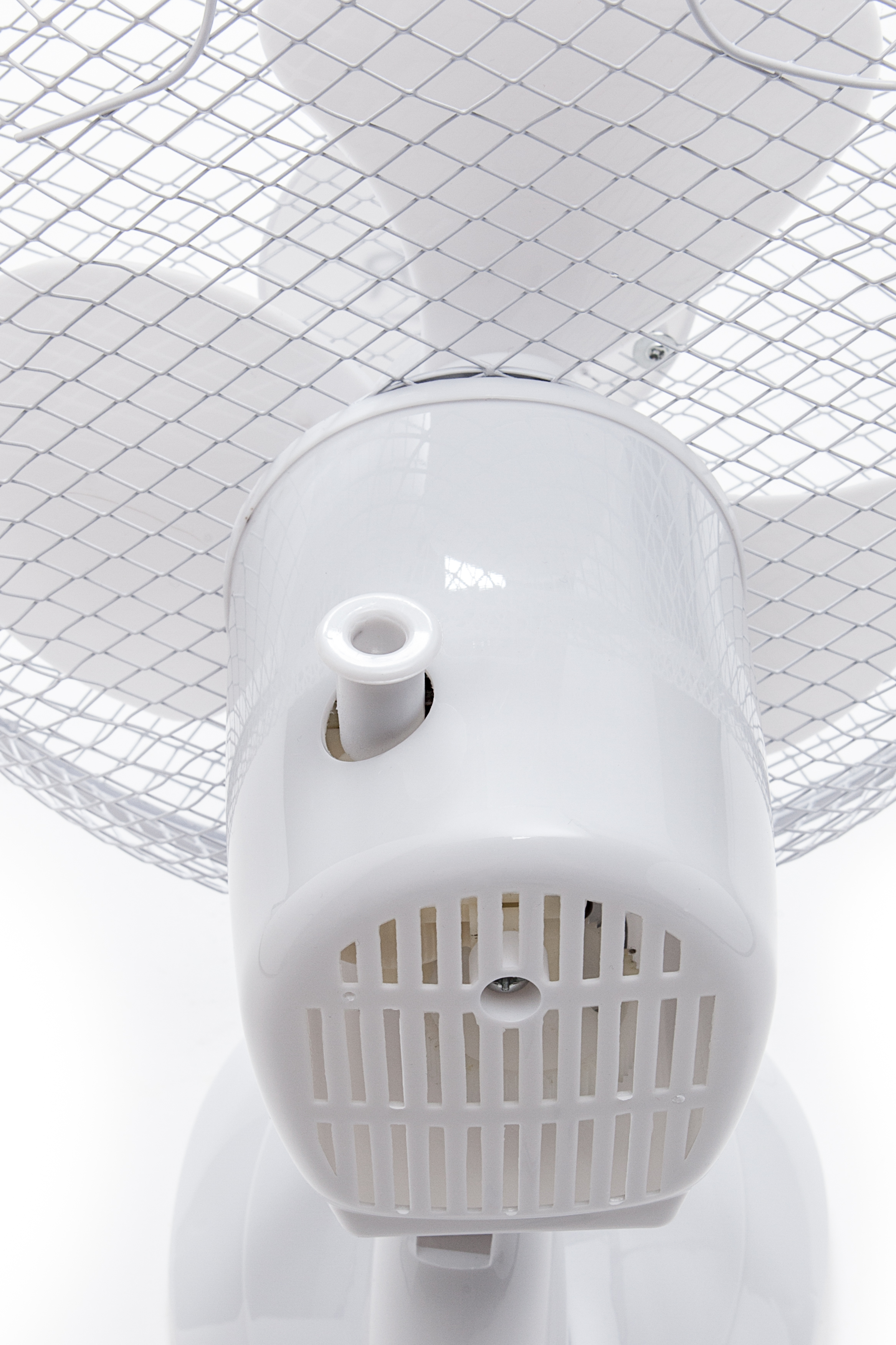 Un ventilateur blanc avec une grille de protection, vue rapprochée.