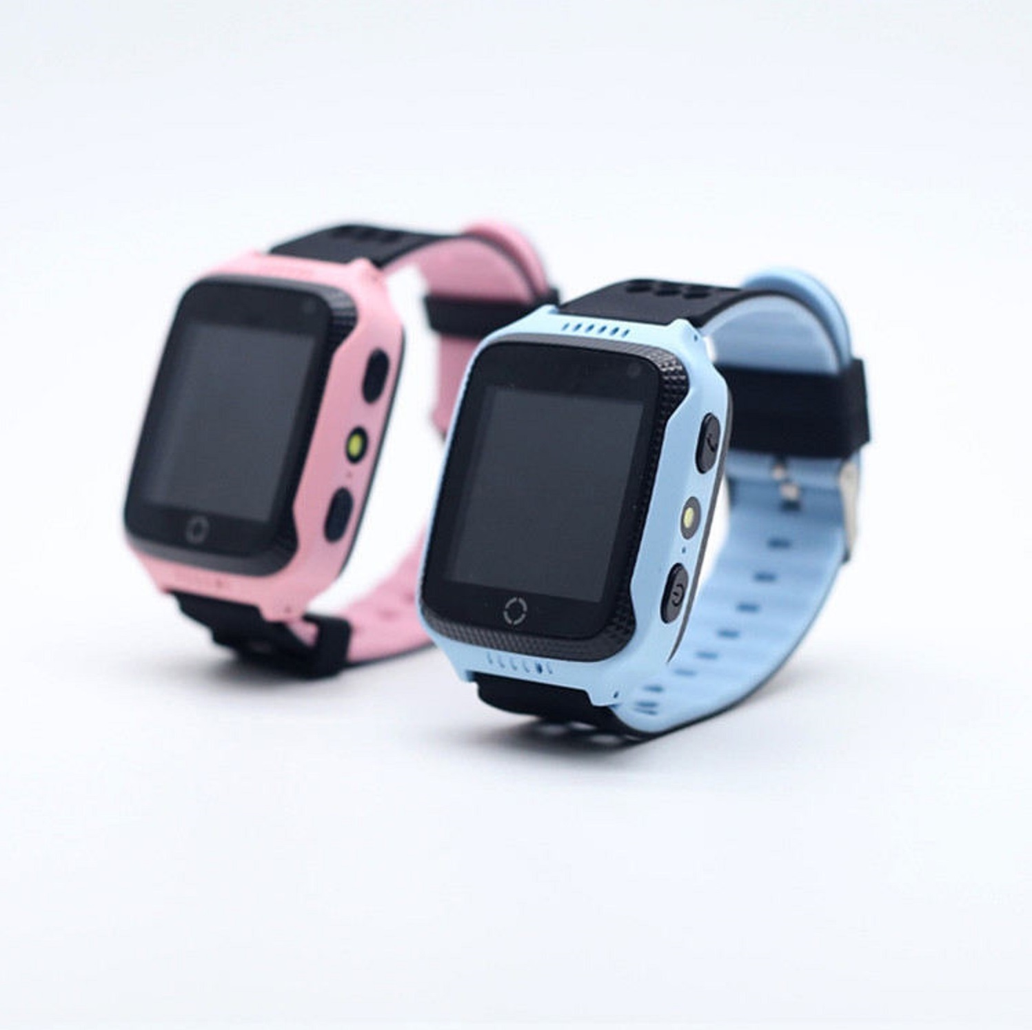 Due smartwatch per bambini, uno rosa, uno blu, con cinturini neri, sono posizionati su una superficie bianca.