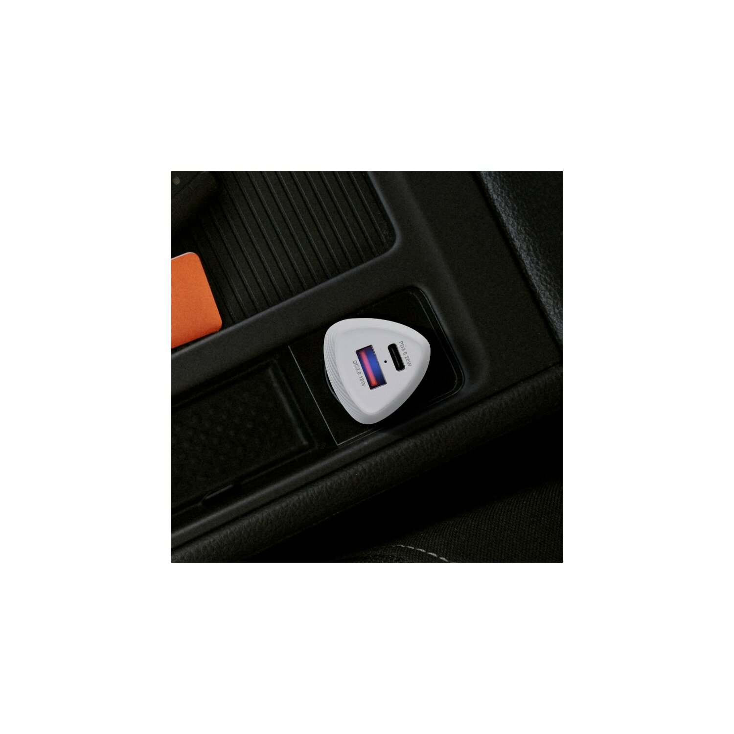 Un caricatore USB bianco a forma di triangolo in una console per auto. Ha porte USB e uno schermo. Sfondo bianco.