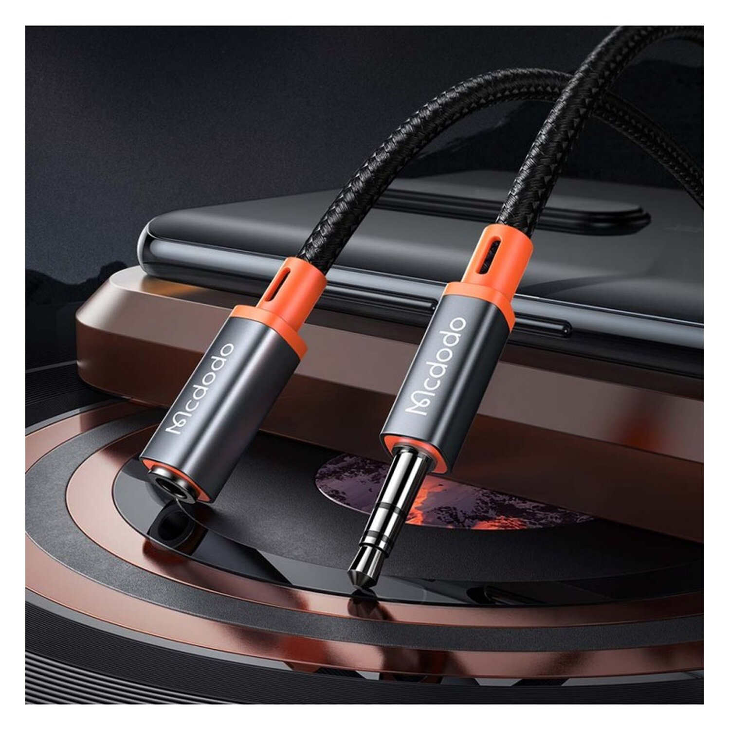 Schwarzes und orangefarbenes Audiokabel mit zwei Anschlüssen, einer für Kopfhörer, einer für Aux.