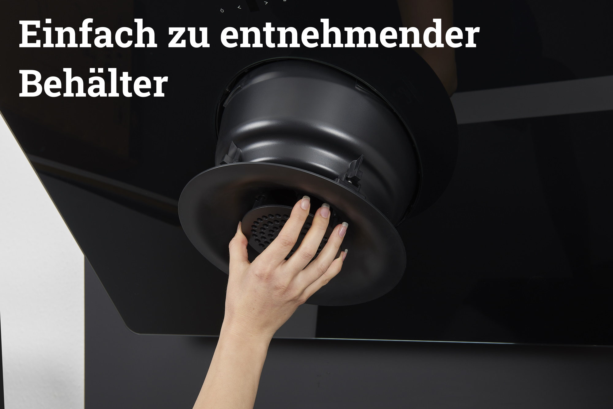 Hand entfernt Filter aus schwarzer Dunstabzugshaube. Text: Einfach zu entnehmender Behälter.