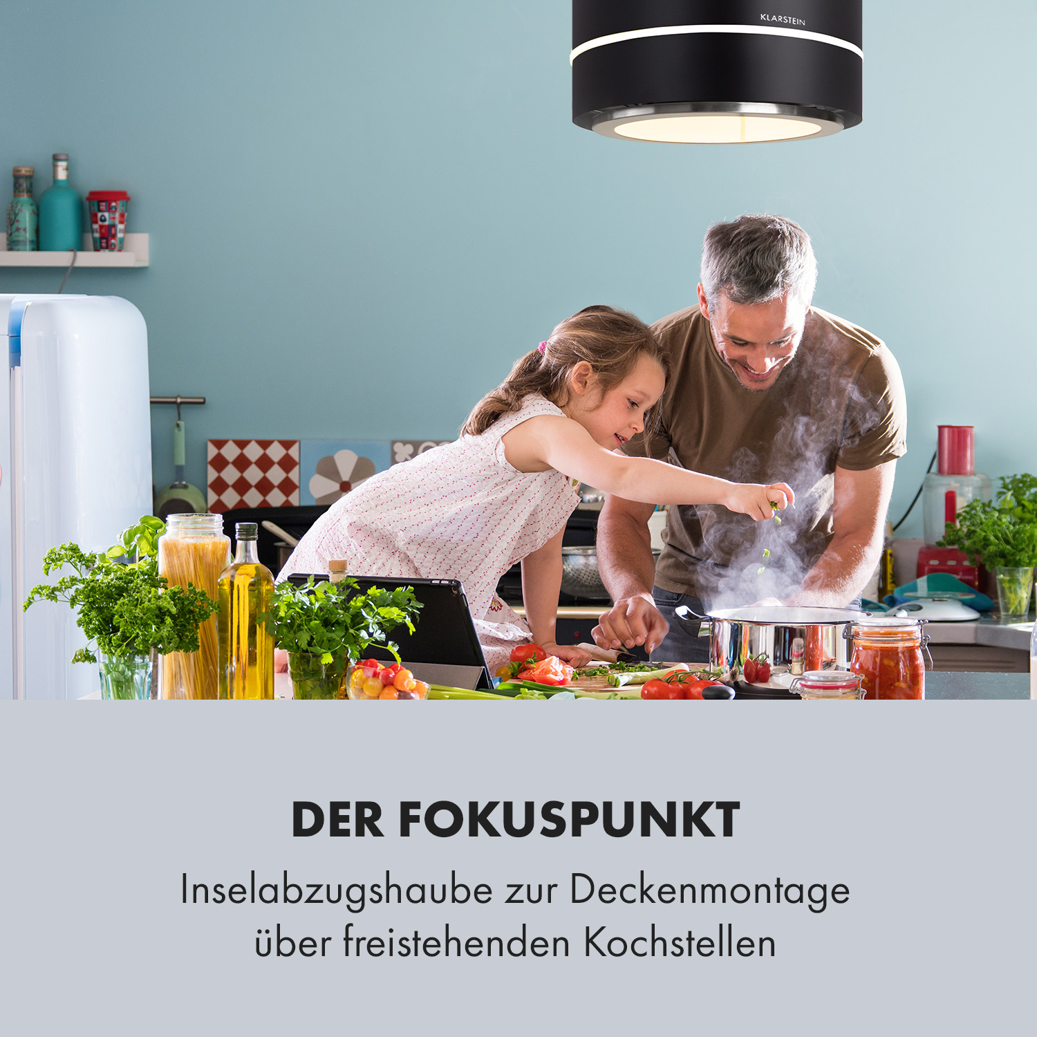 Ein Mann und ein Mädchen kochen, mit einer Dunstabzugshaube über ihnen und Text zum Produkt.