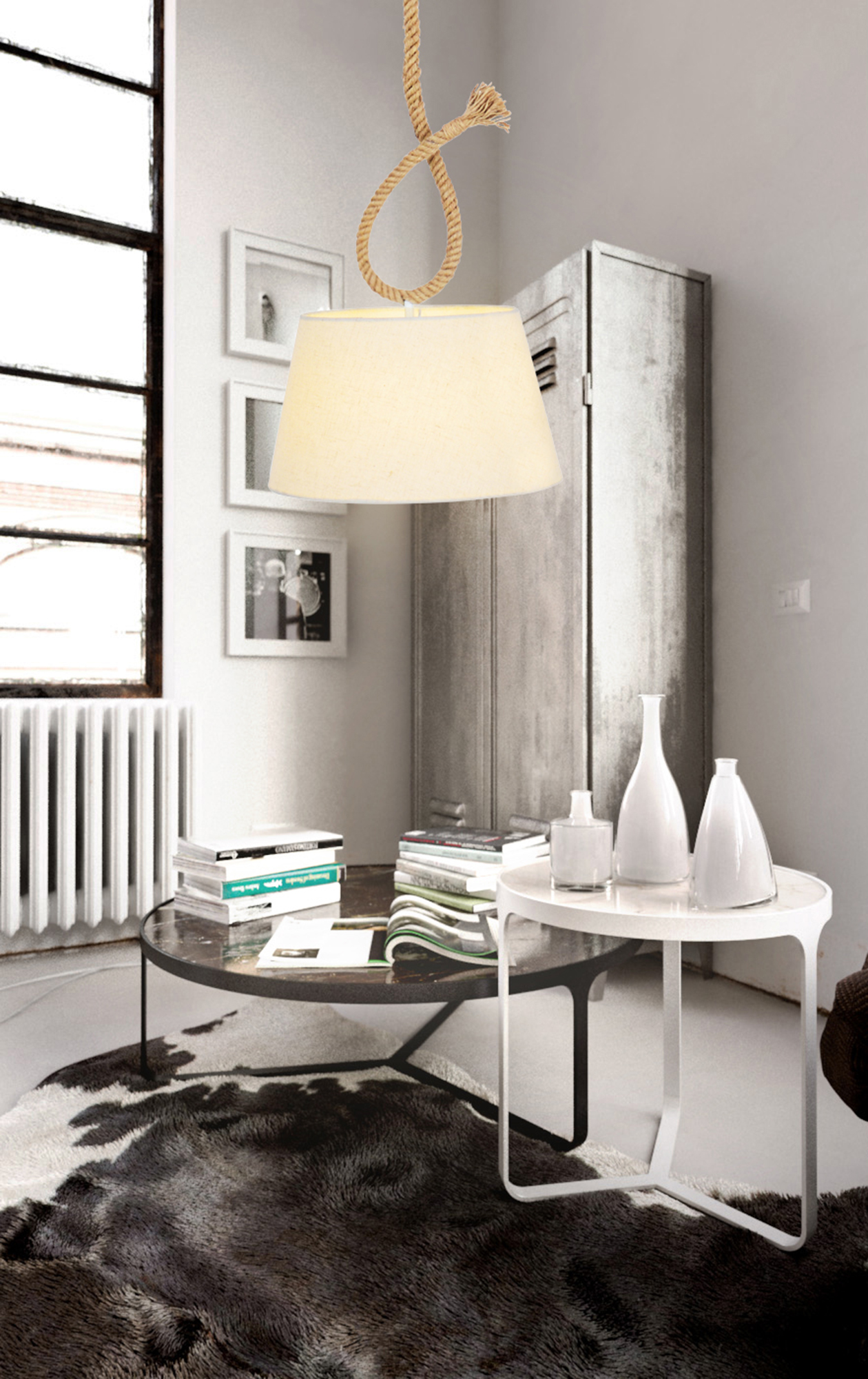 Eine Lampe mit Seil hängt von der Decke in einem Raum mit weißen Möbeln.