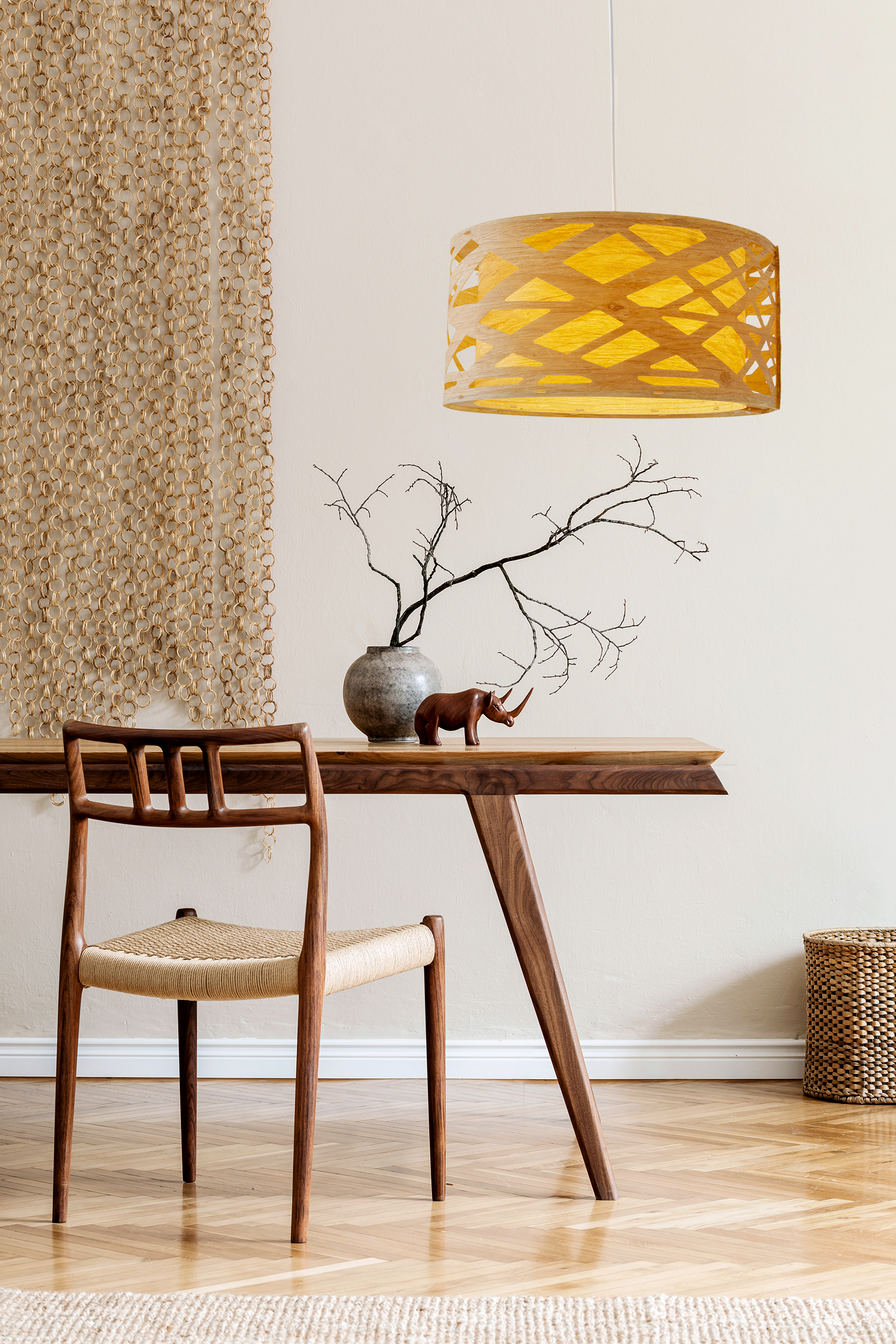 Interieur mit Tisch, Stuhl, Pendelleuchte und einem Teppich auf einem Holzboden.